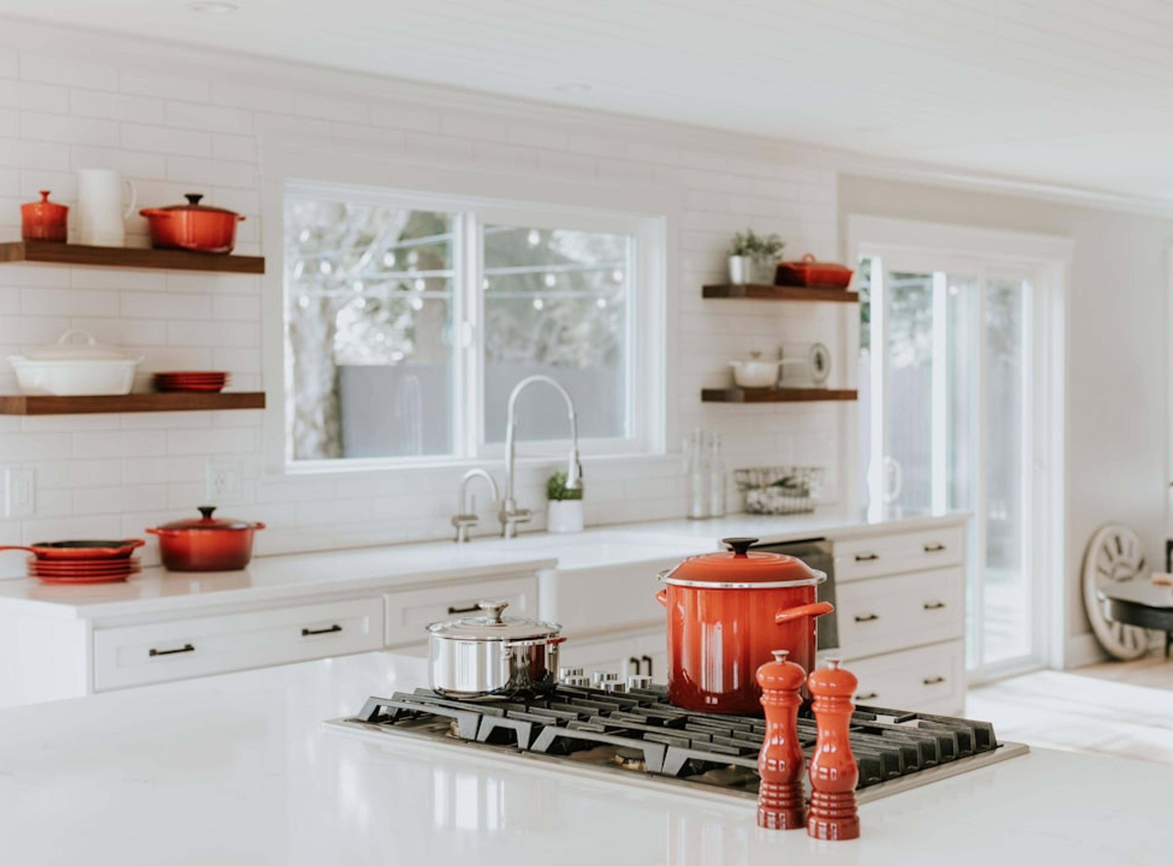 Open shelving with styled cookware in a white kitchen