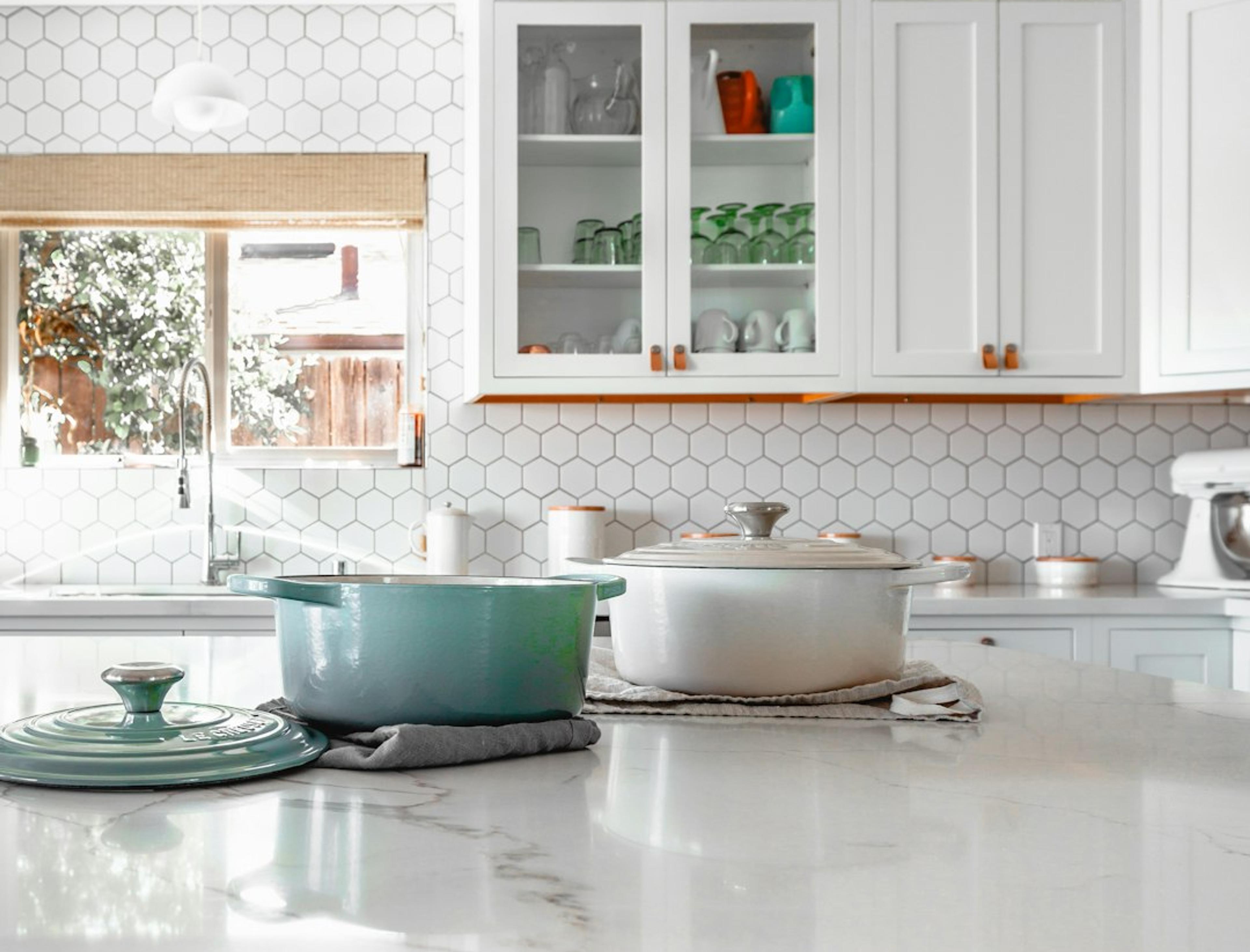 White kitchen detail with glass-front cabinet and marble-look countertop