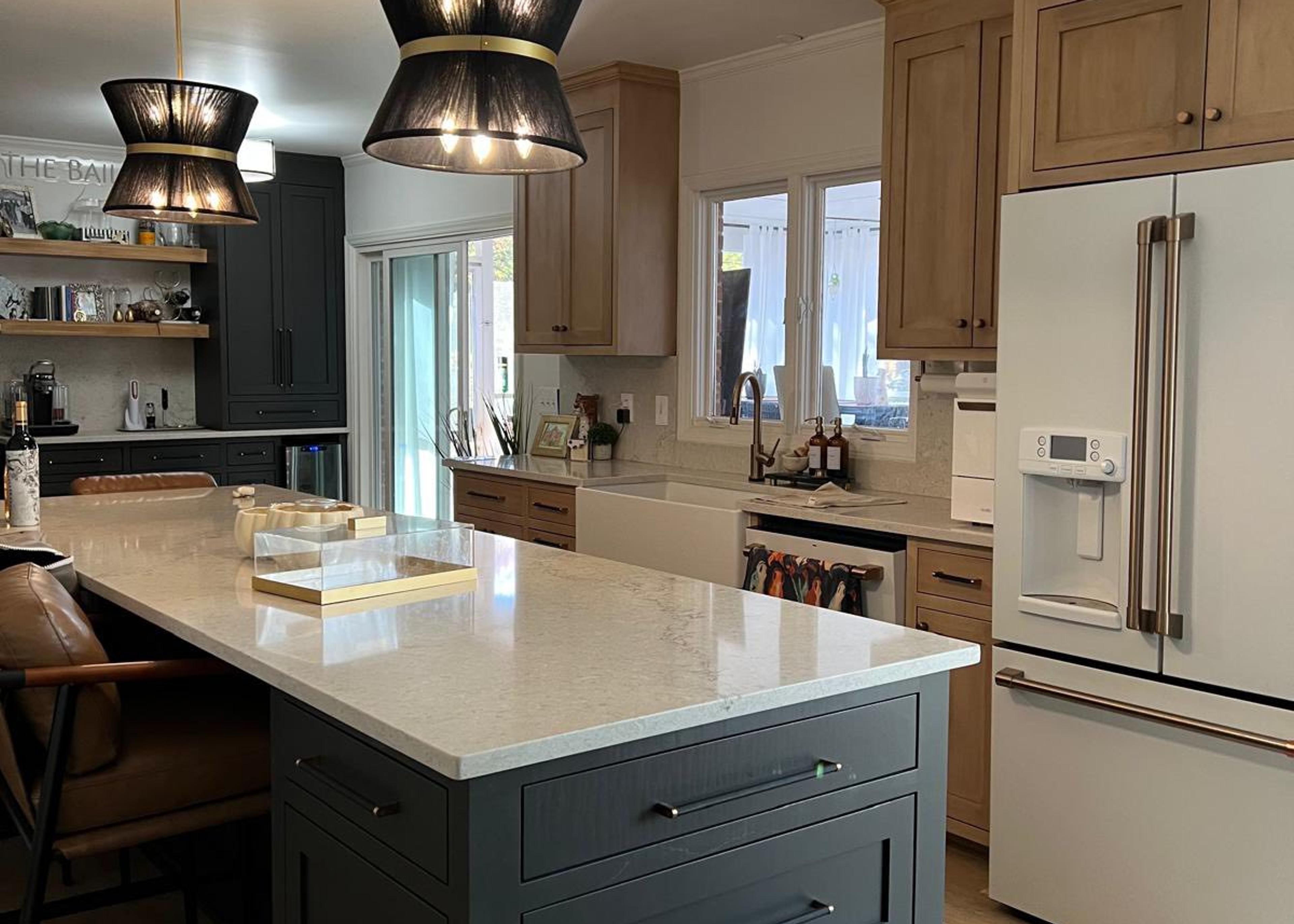 Completed two-tone kitchen with green island and farmhouse sink