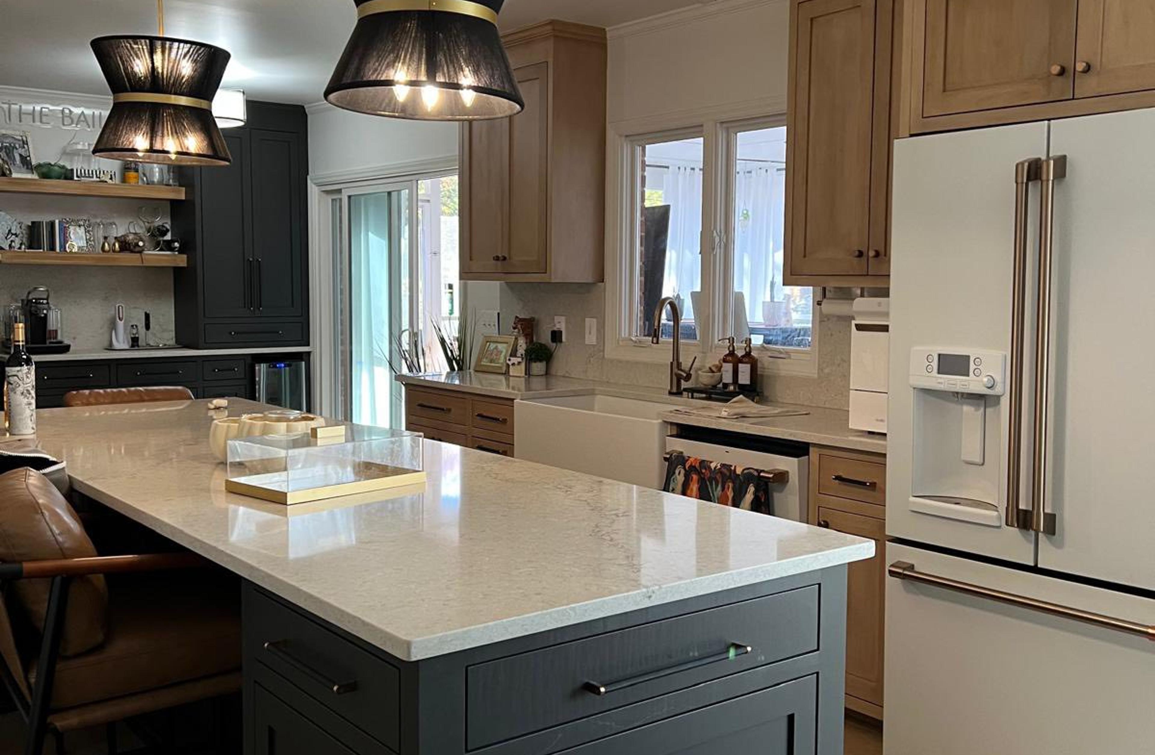 Two-tone kitchen with dark green island and cream perimeter cabinets