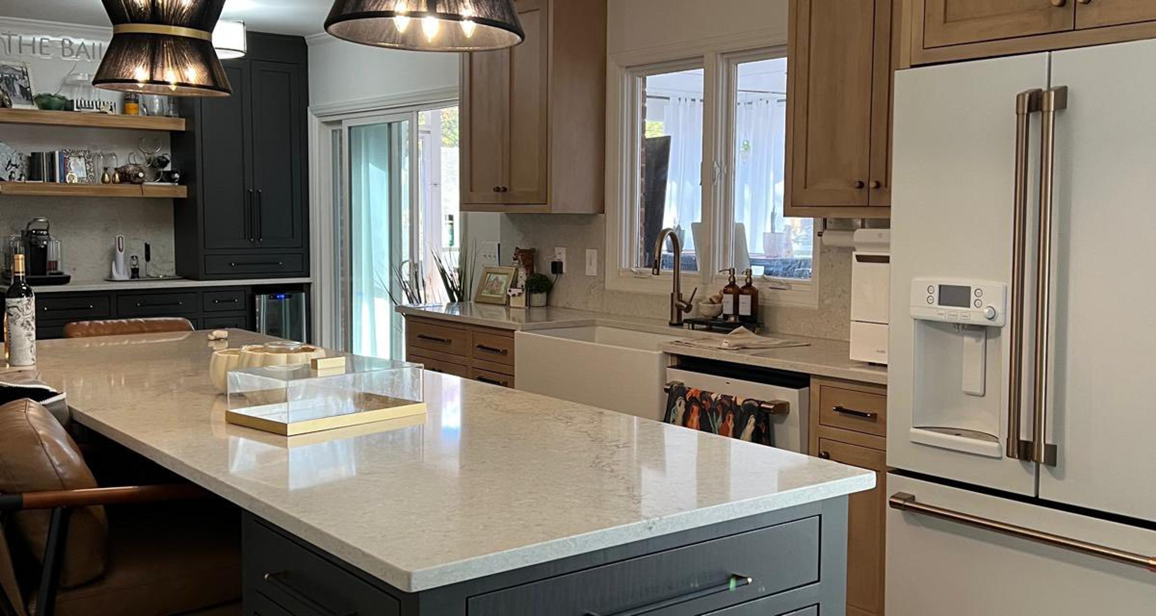 Two-tone kitchen with dark green island and cream perimeter cabinets