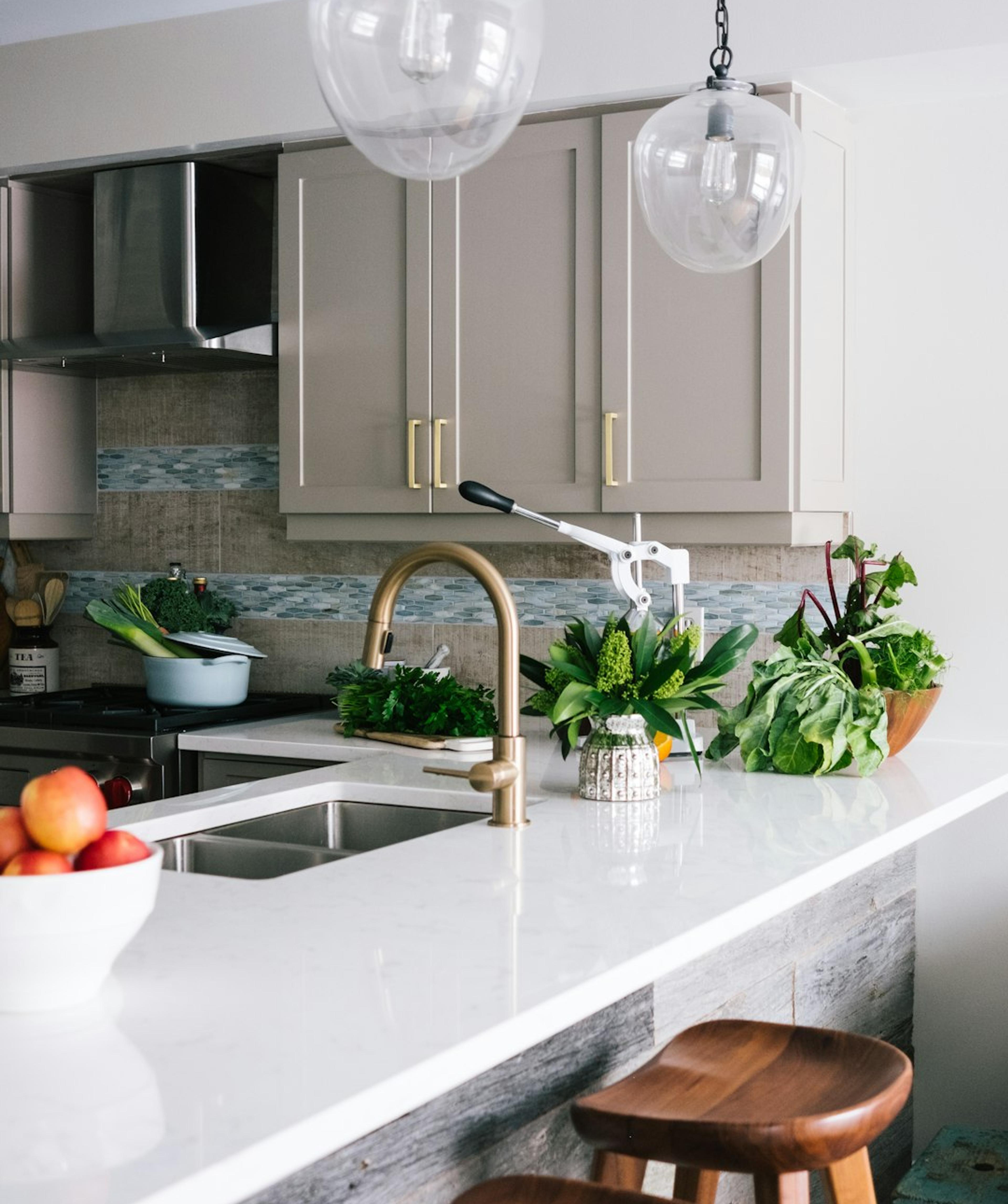 Greige shaker kitchen with brass accents and quartz island
