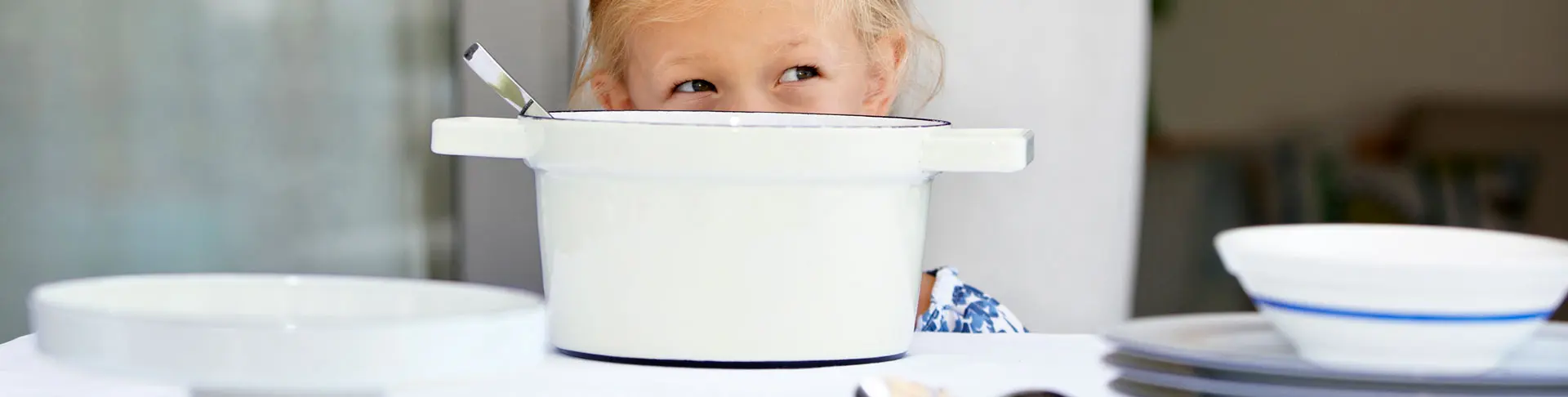 Kind lächelt hinter einem Aromapot