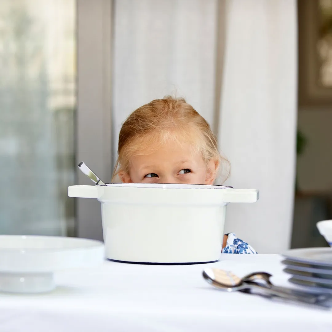 Kind spitzt hinter Aromapot Topf hervor