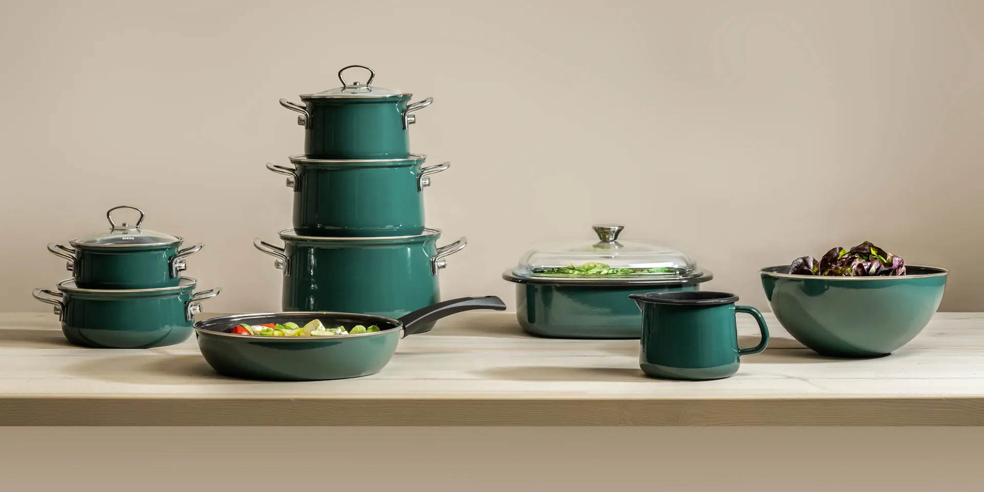 Verschiedene Formen von Kochtöpfen, Pfanne und Schüsseln in einem blaugrünen Teal. 