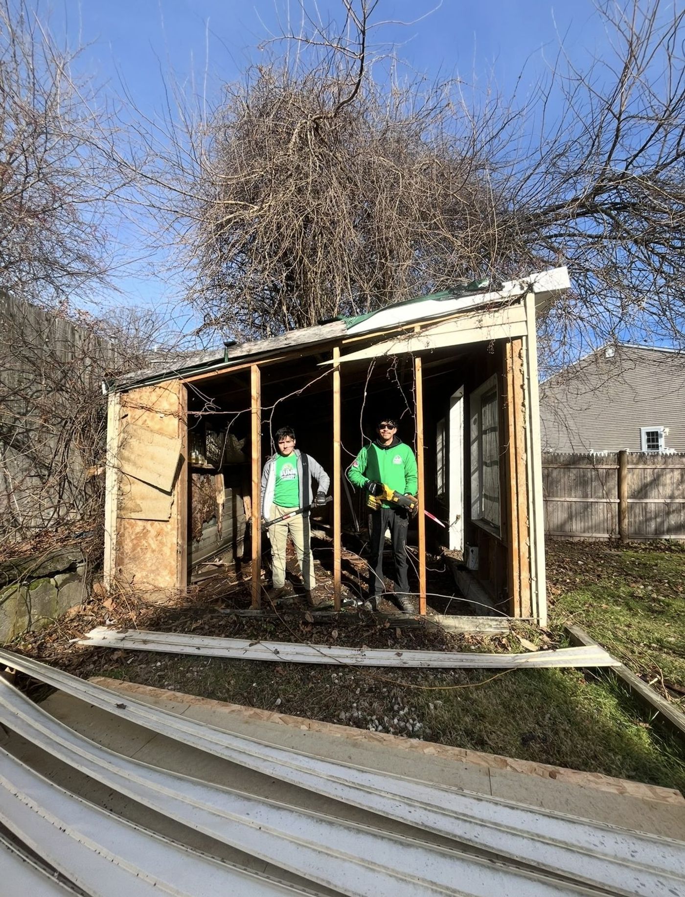 Crew members inside an old shed being torn down by hand