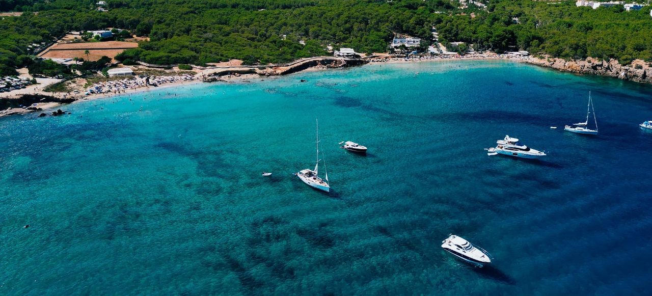 Aerial photo of coastline cala nova with sailing yachts blue sea. Ibiza, Balearic Island