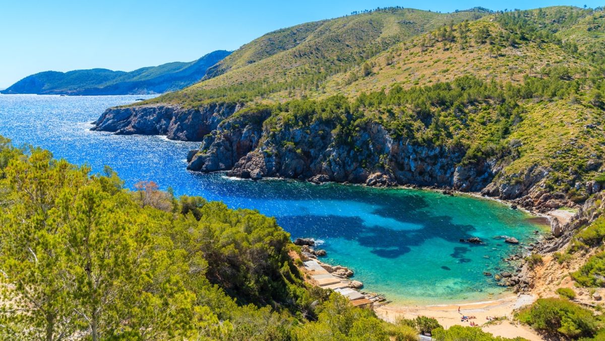 View of secluded Cala d'en Serra beach and coastal cliff rocks, Ibiza island, Spain