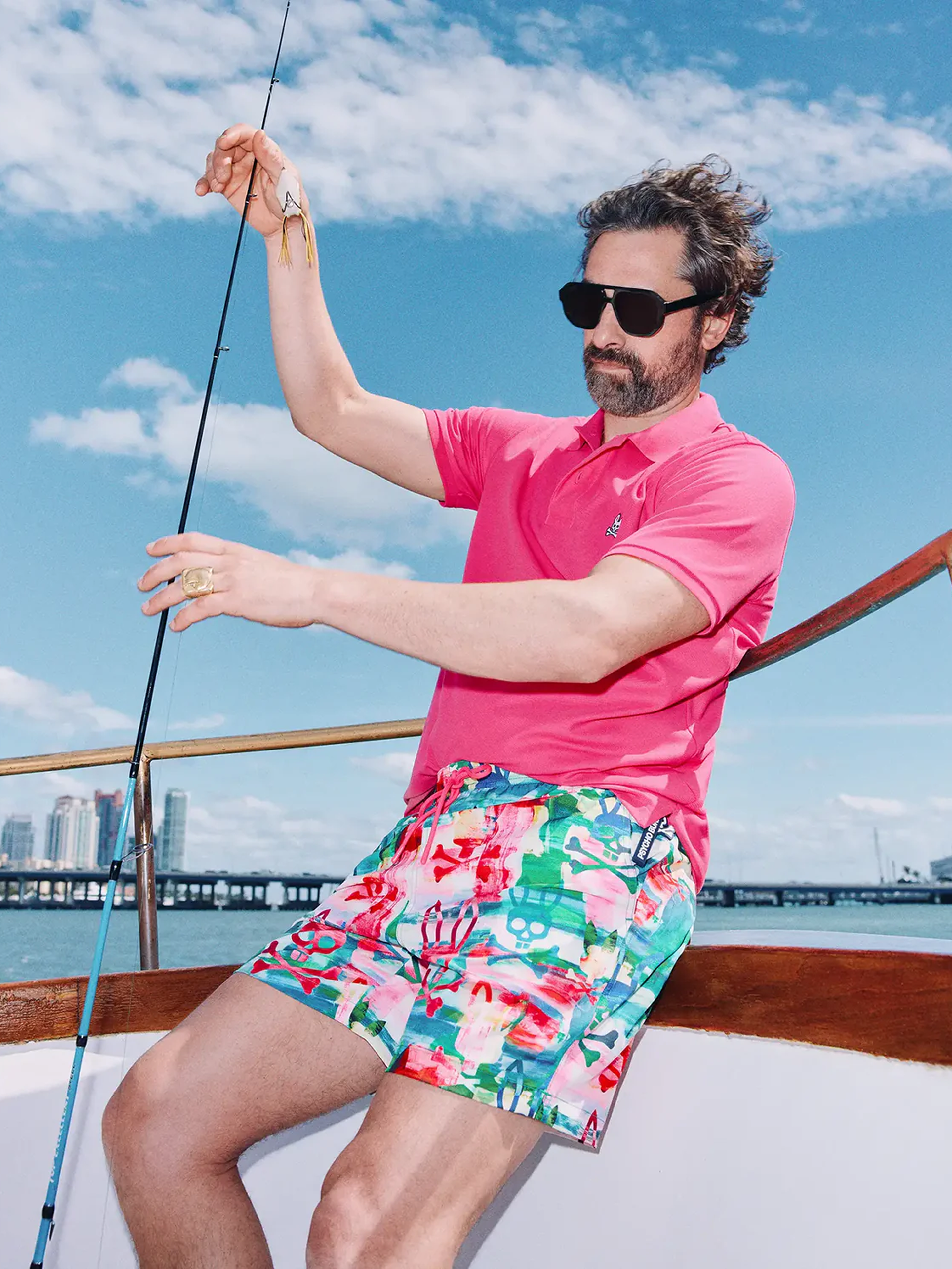Model wearing Psycho Bunny shirt and shorts on a boat