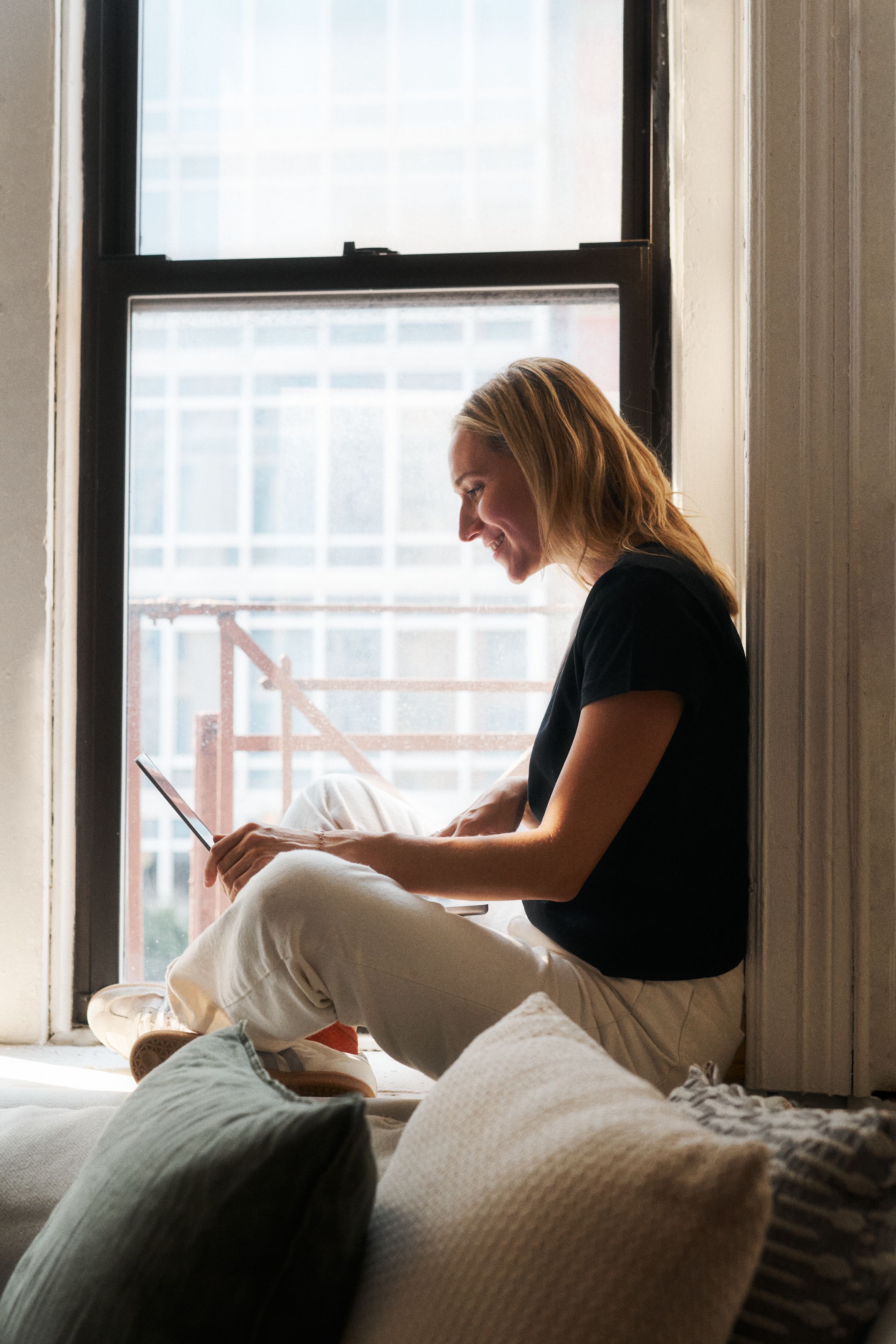 Woman using a computer beside a window