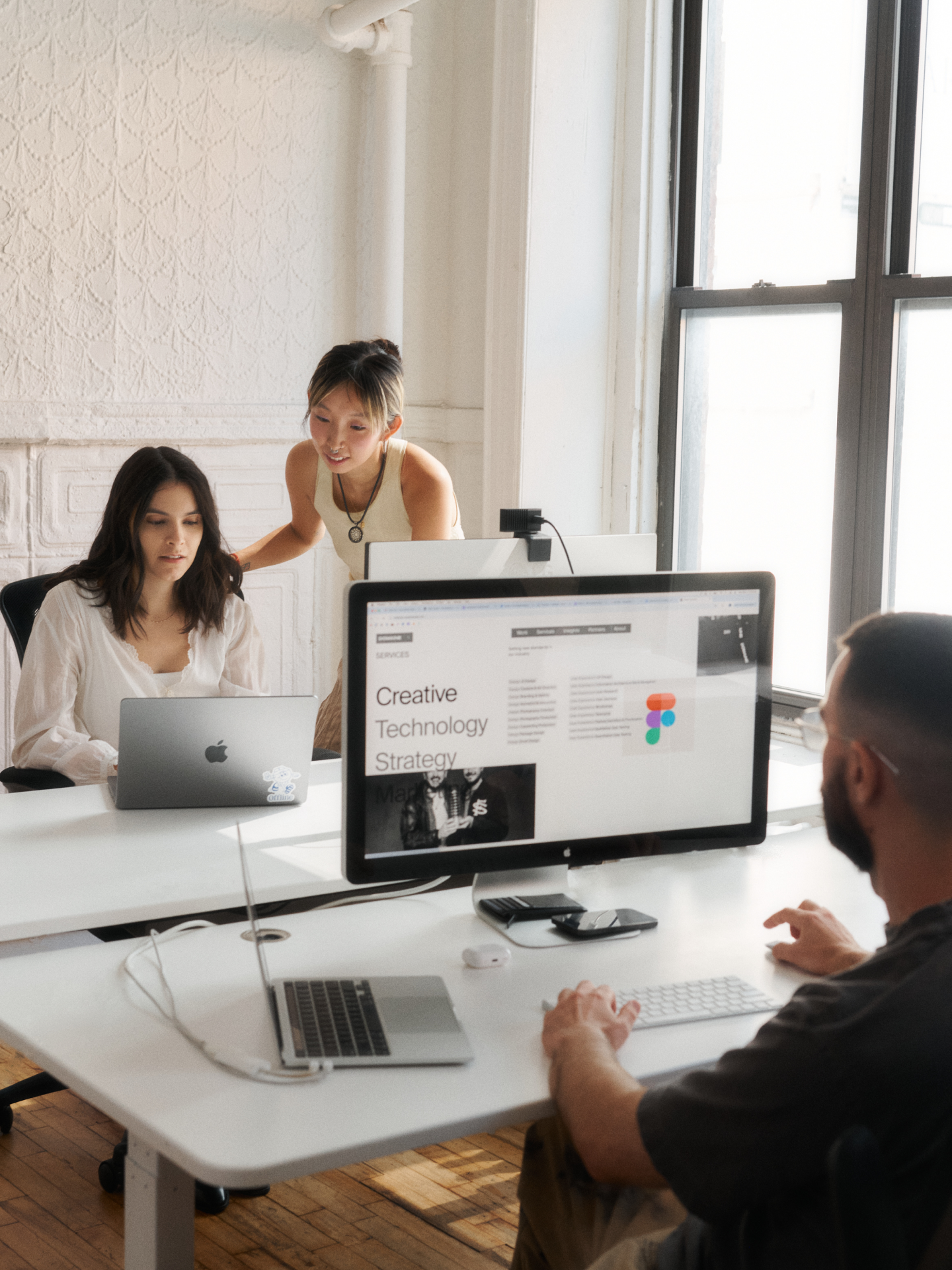 Team members huddling over computers