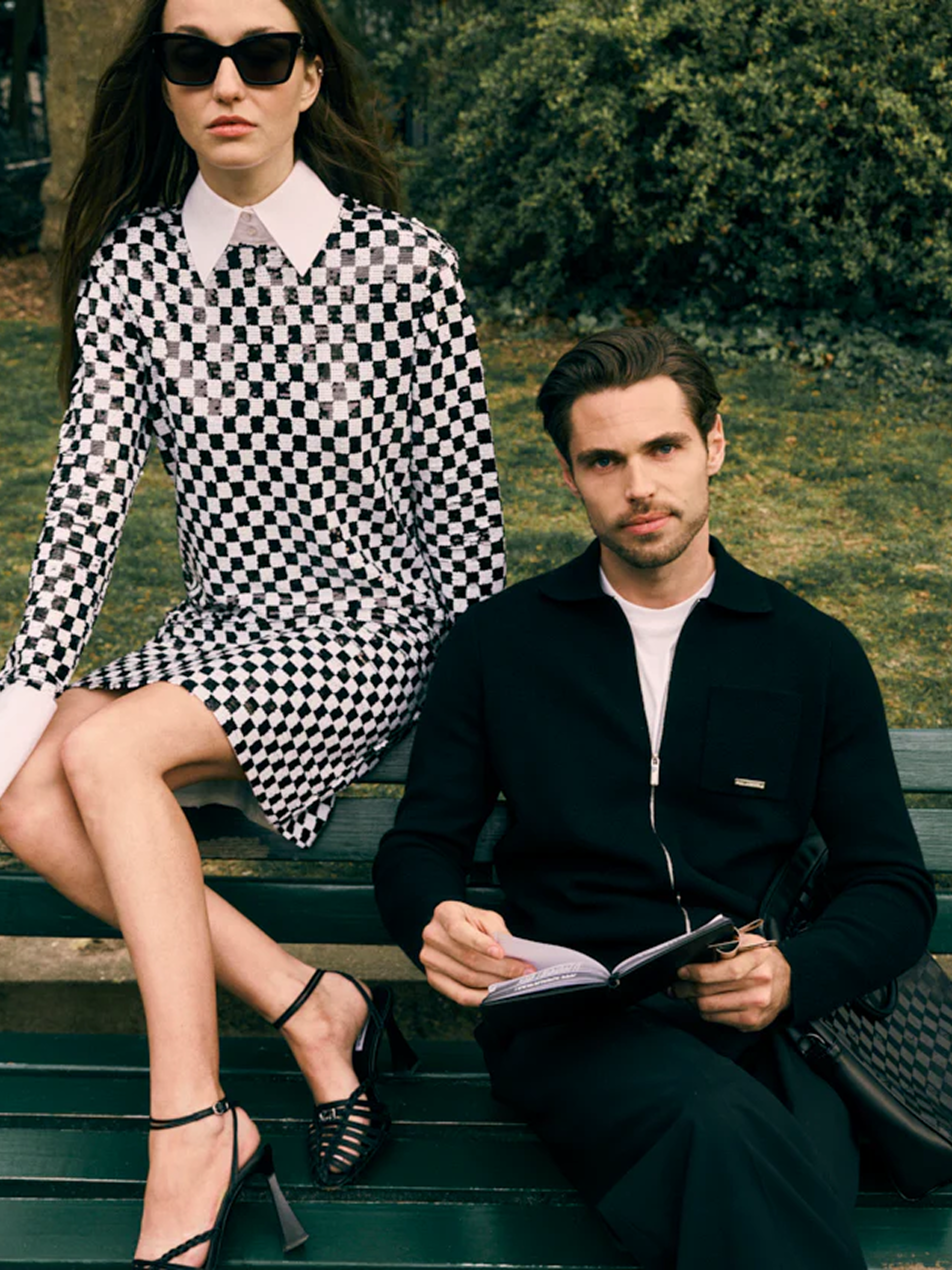 models sitting on park bench