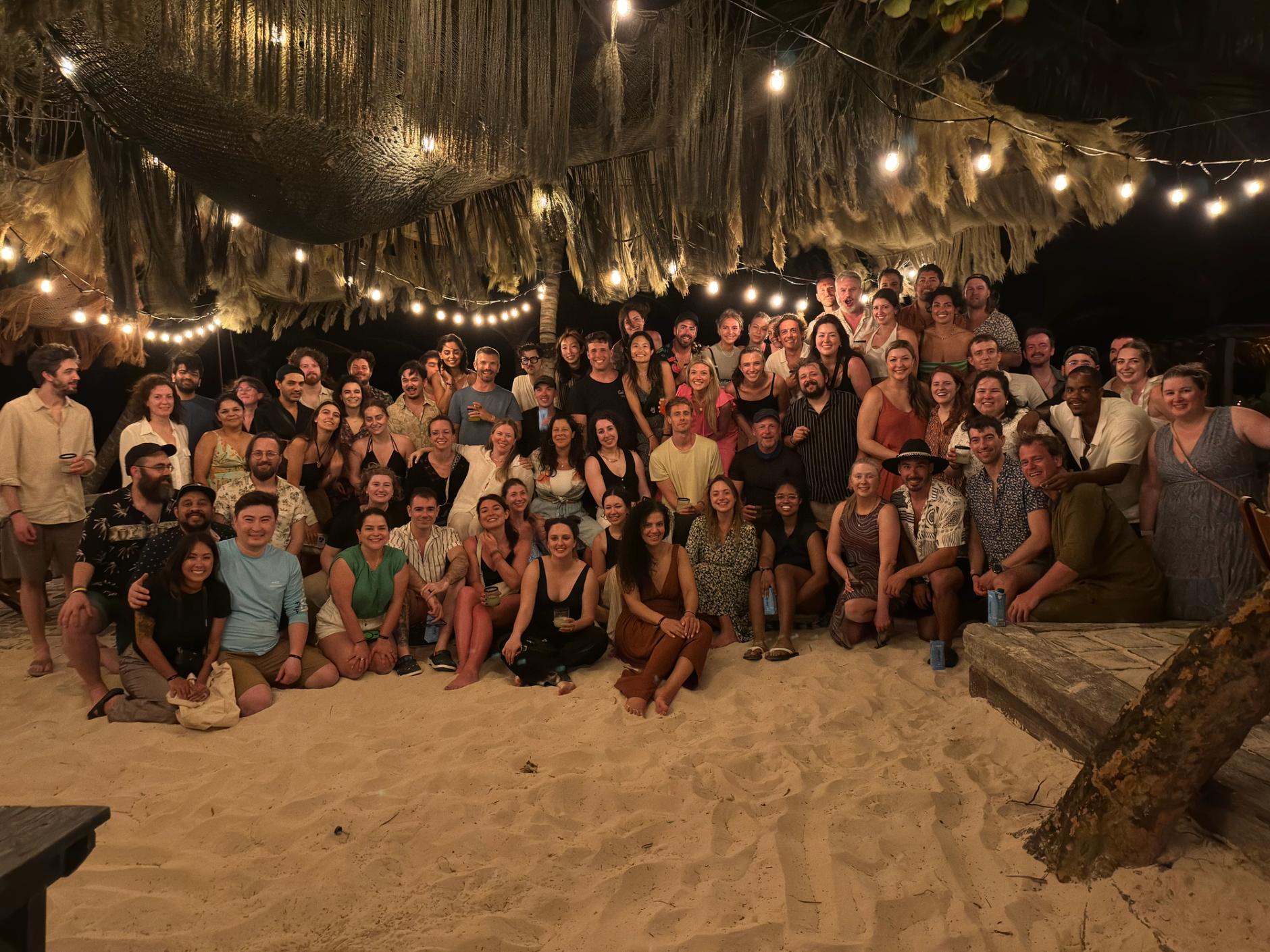 Group photo of the entire Domaine team on the beach during the offsite in Tulum