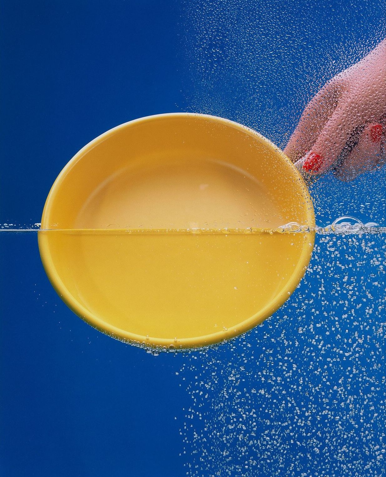 a yellow bowl halfway submerged in water