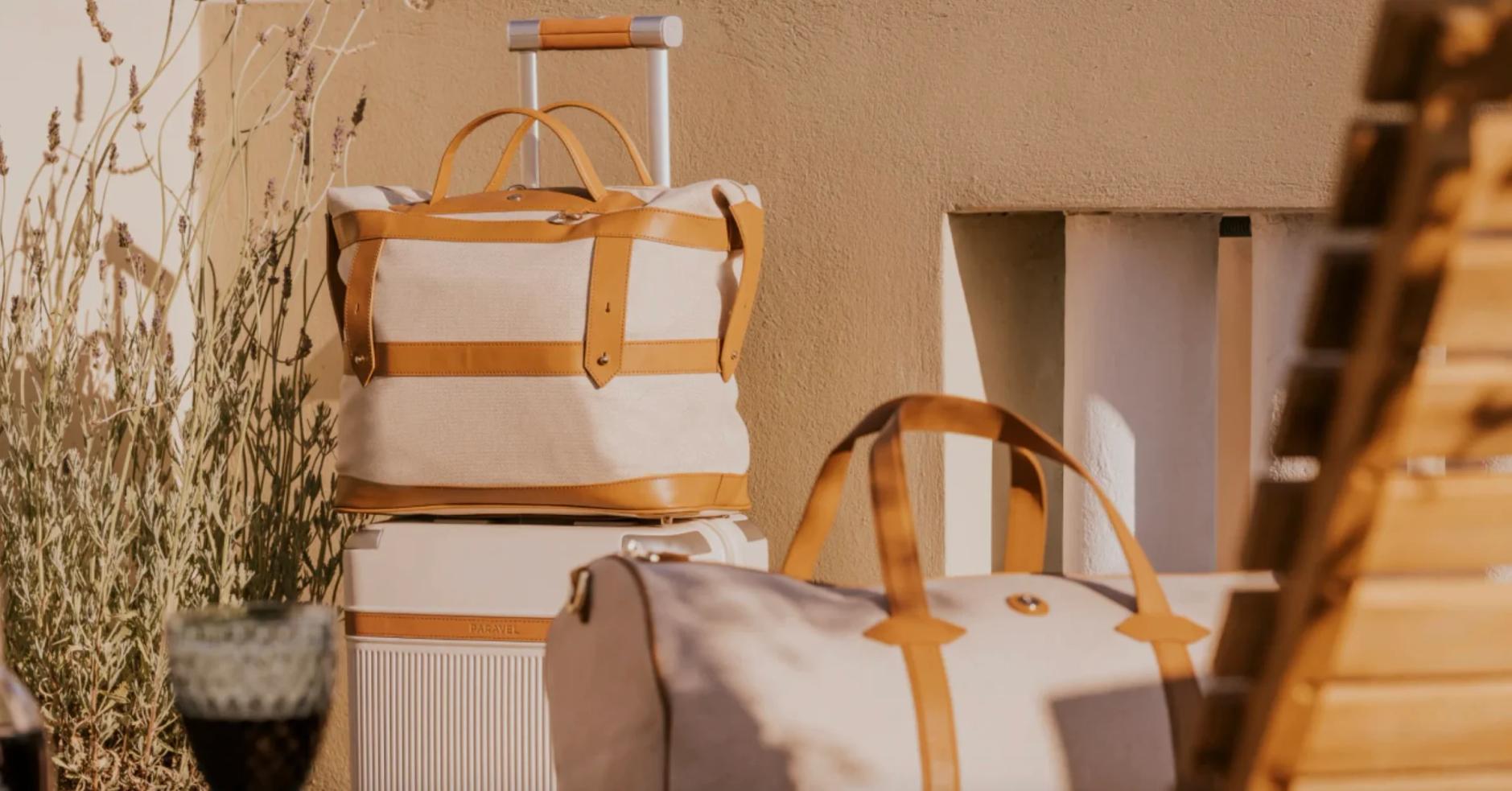 Paravel bags and luggage in front of a light brown building