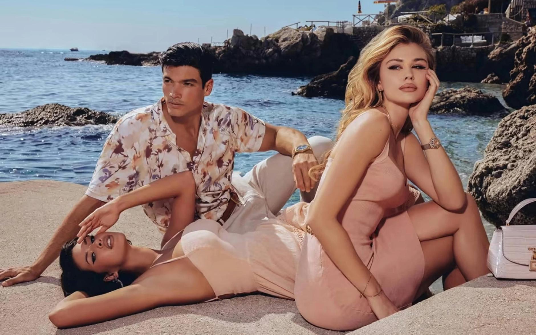 Various models weearing watches sitting on a beach