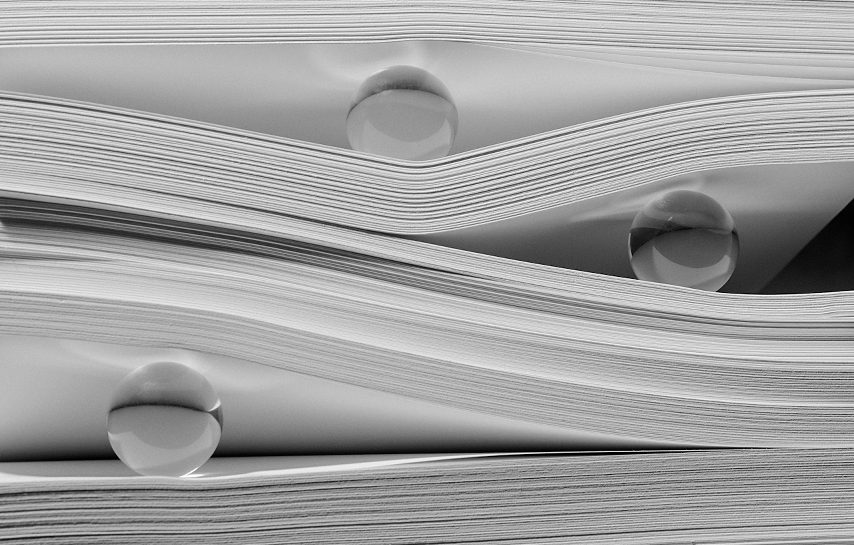 Glass balls stuck between pages of paper