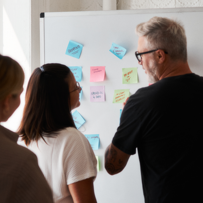 Team members talking in front of a whiteboard