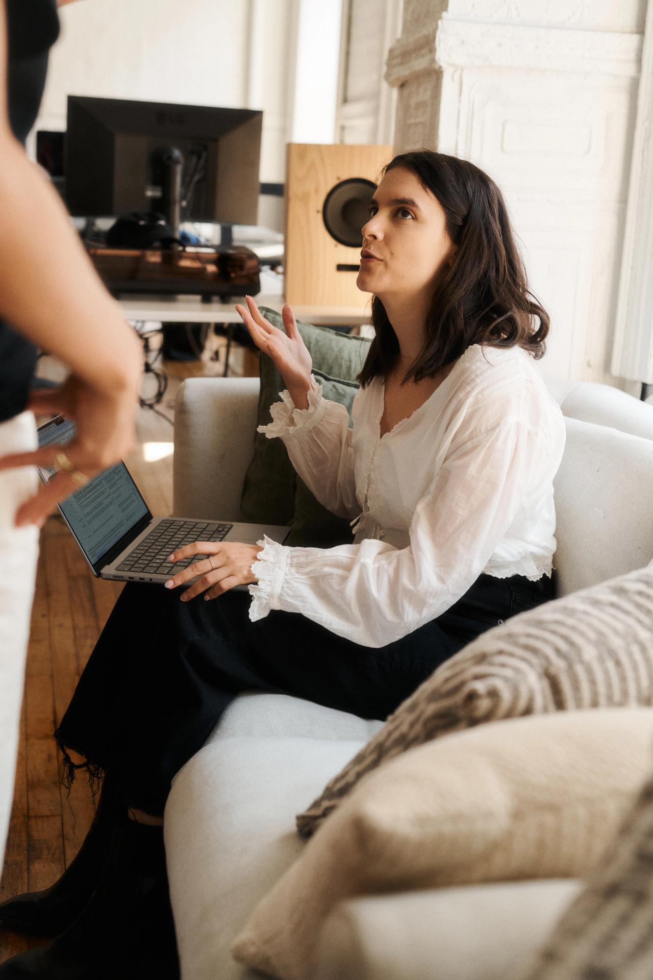 Rae on couch speaking with her coworkers