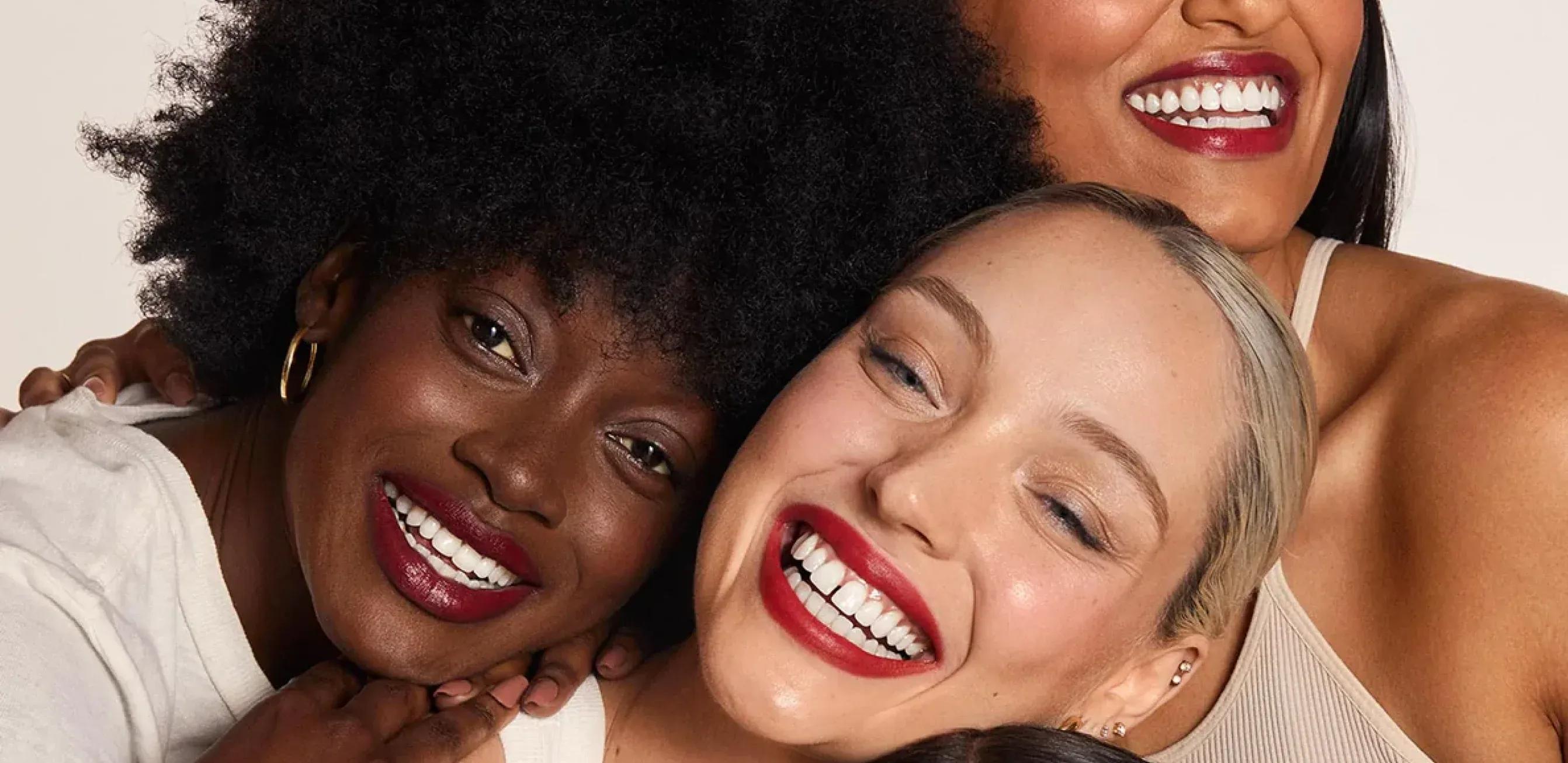 Four smiling women wearing Lip Lab lipstick