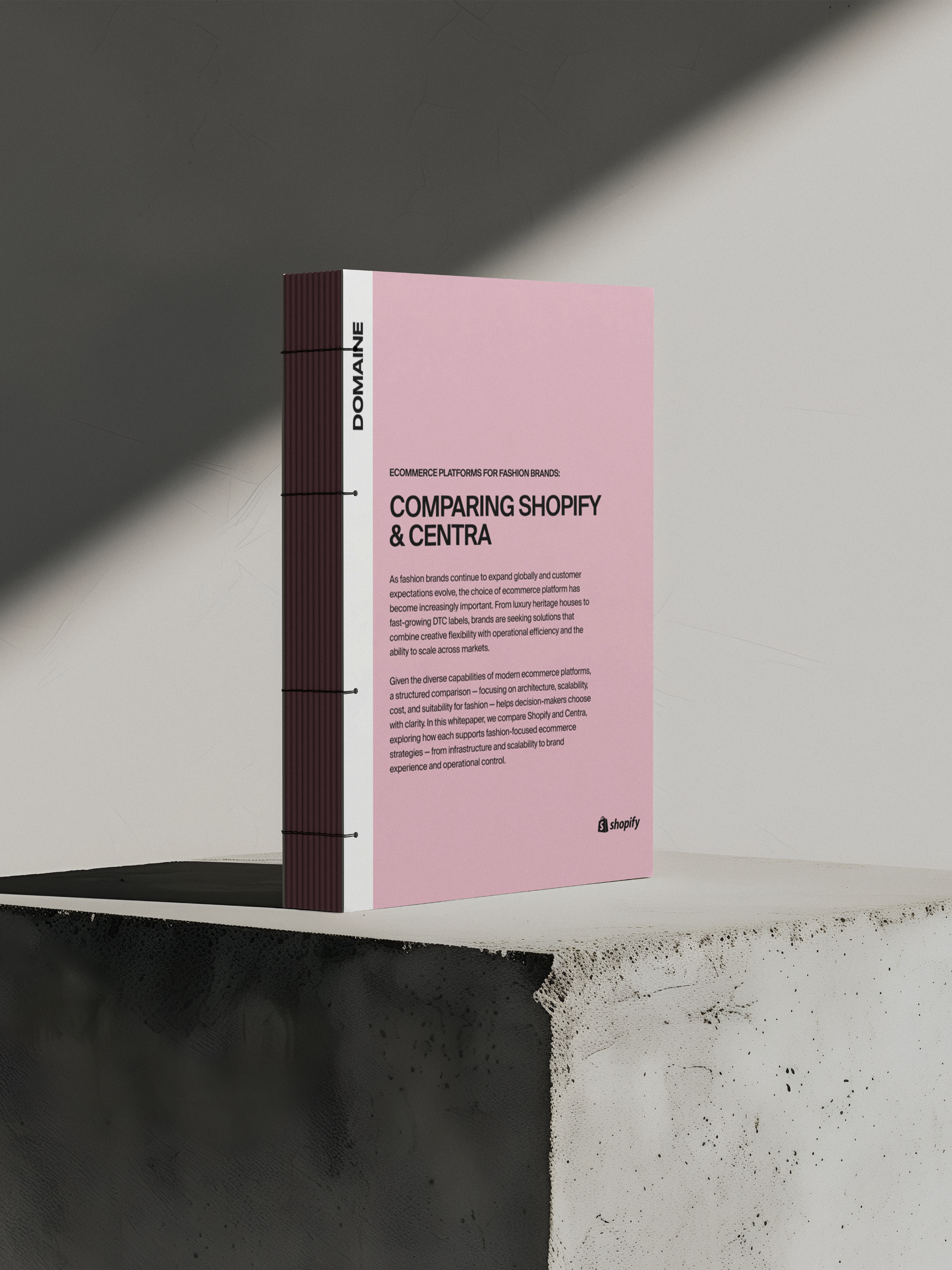 Mockup of Shopify vs Centra comparison guide on a grey background and cement block