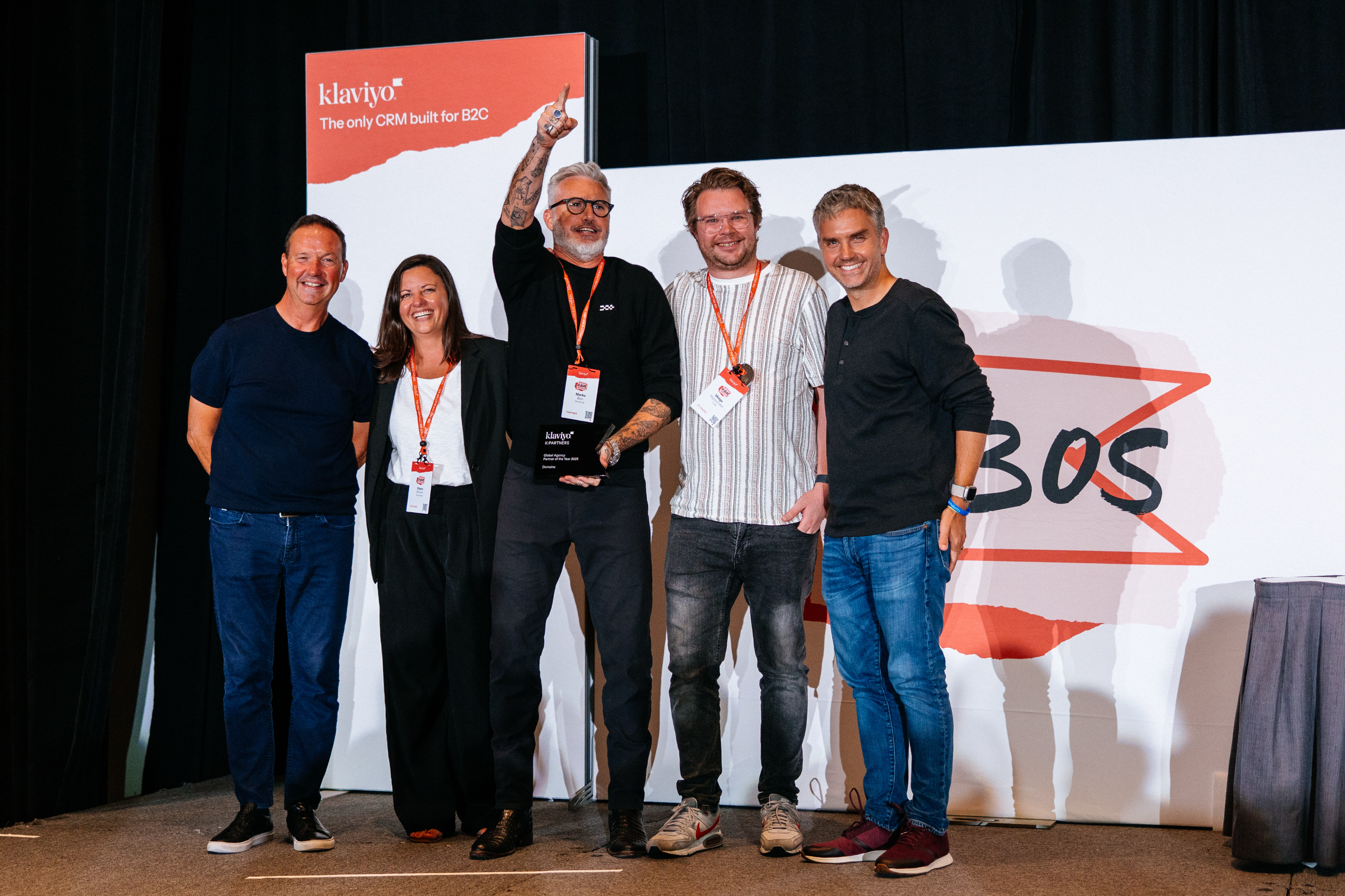 Stacy, Marko, and Midge from the Domaine team alongside Klaviyo presenters, receiving the award onstage at K:BOS