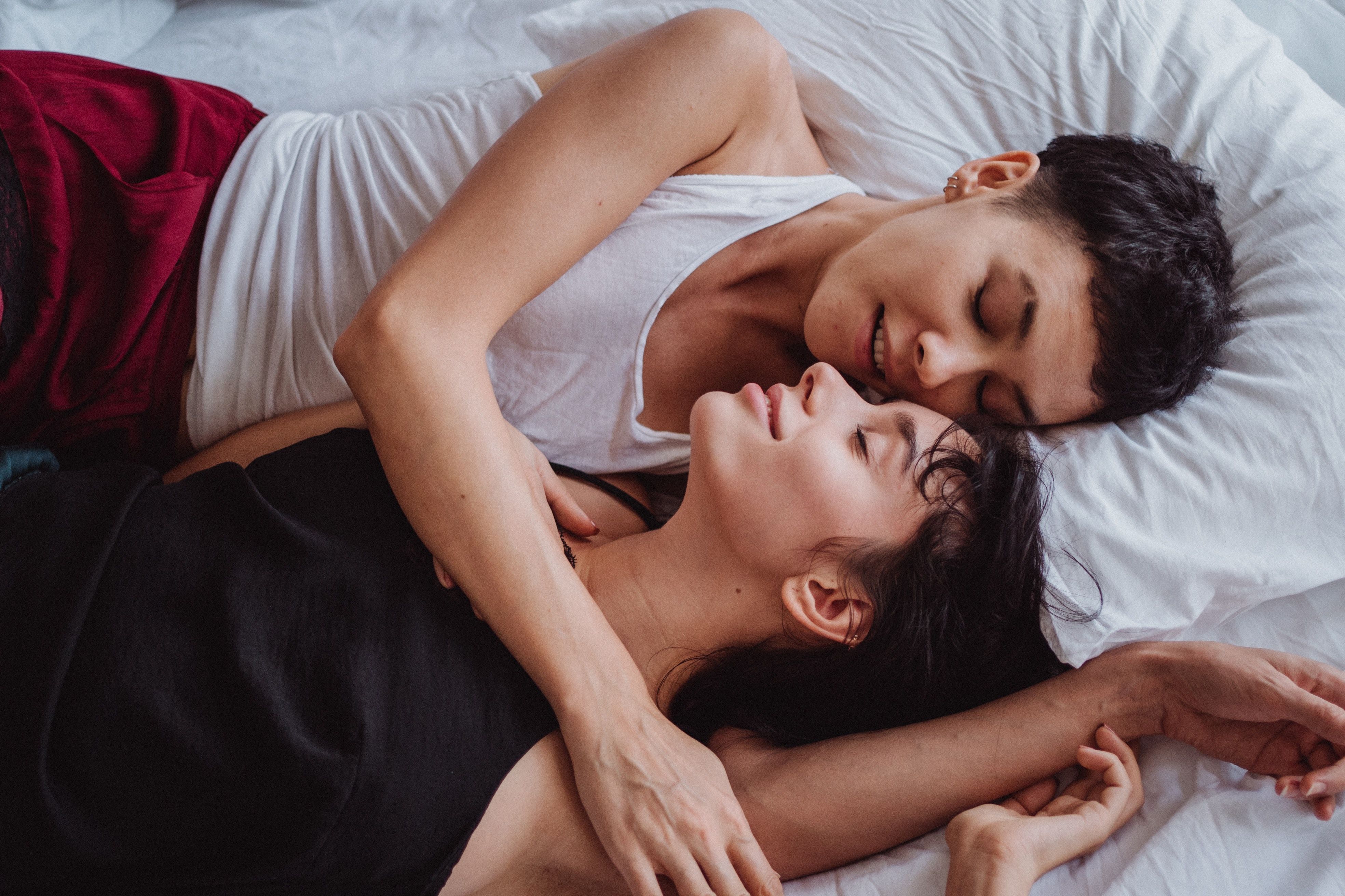 Two women cuddling in bed