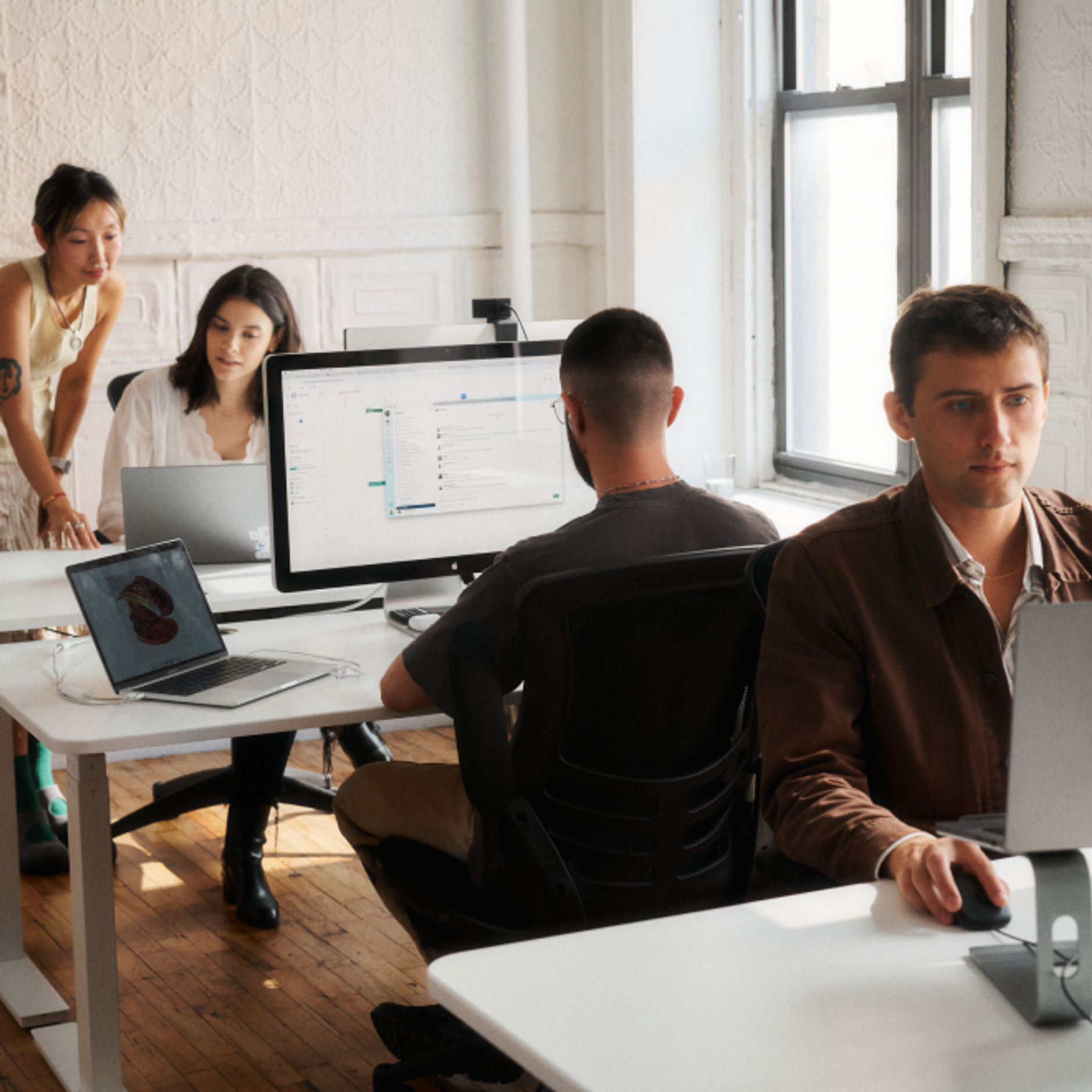 Tiffany, Rae, Paul, and Milo working in the office