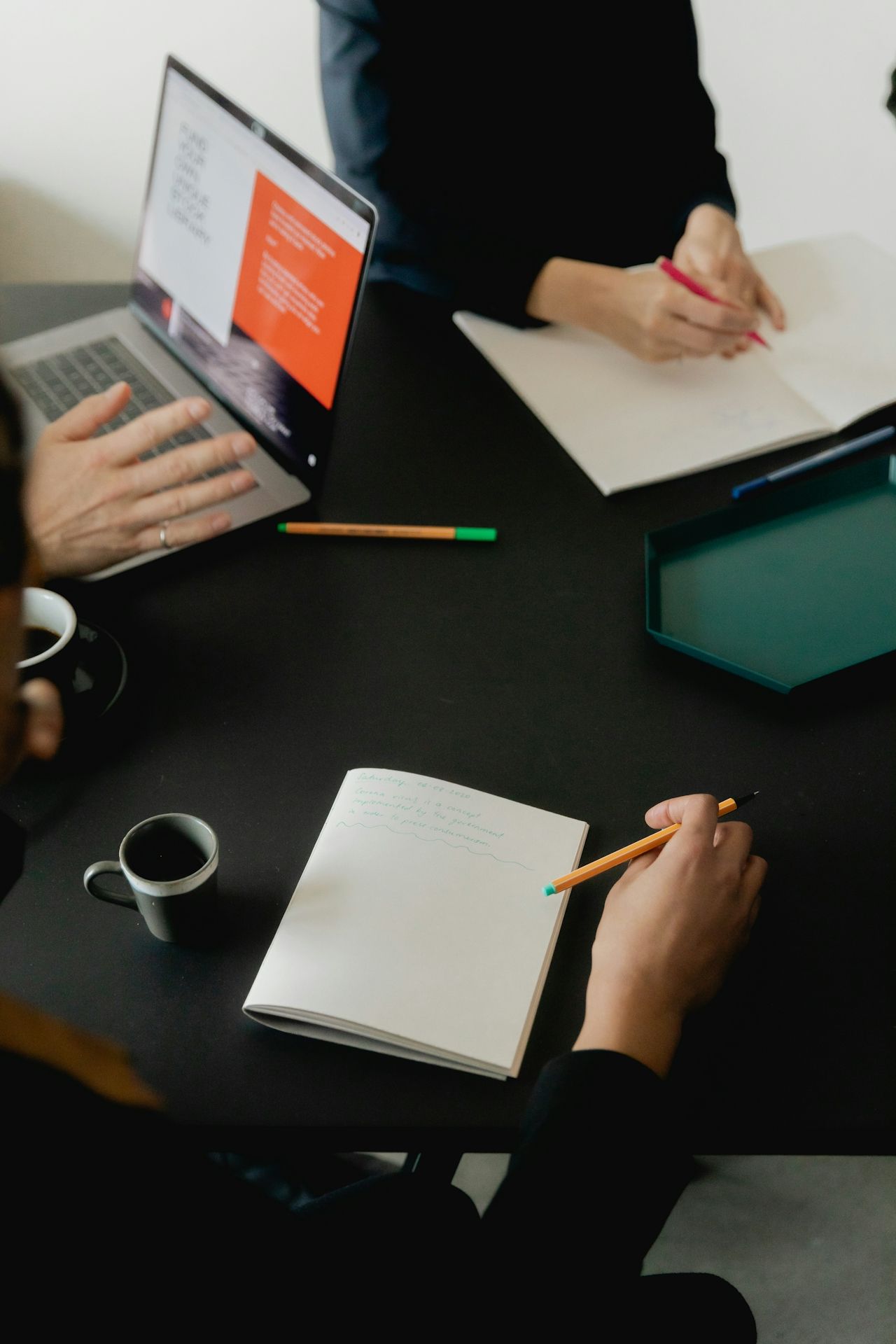 People seated across a table while taking notes