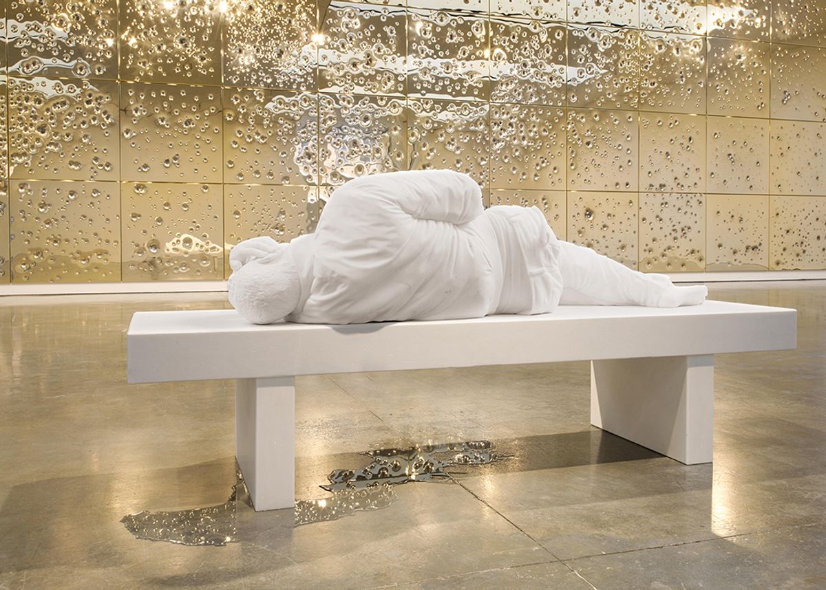 Maurizio Cattelan’s marble sculpture November sits in front of Sunday, a 68ft-wide wall of highly polished gold-plated and stainless-steel panels pockmarked by bullets
Photo: Maris Hutchinson. © The artist, courtesy of Gagosian
