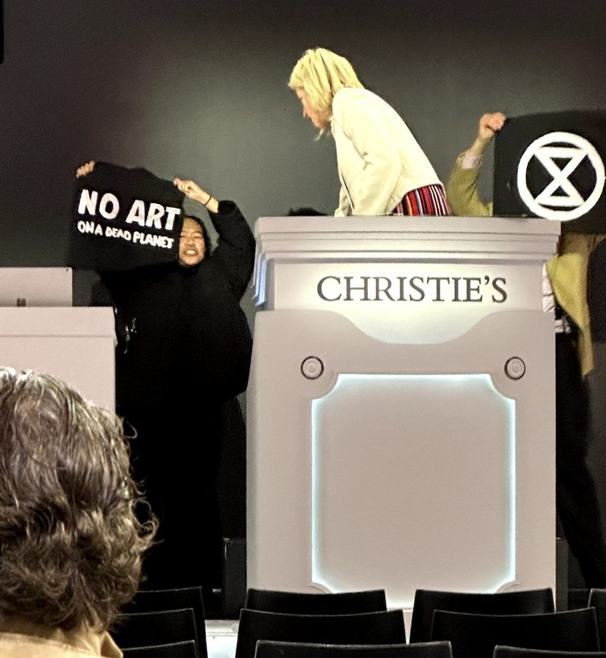 Image of Extinction Rebellion activists storming the rostrum at Christie's Extinction Rebellion