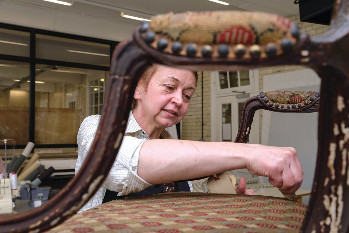 Isobel Harcourt works on the disintegrating upholstery and flaking paint of a Georgian chair, one of around 250,000 V&A objects being catalogued and conserved before the museum vacates its Blythe House stores at the end of 2022 © Victoria and Albert Museum
