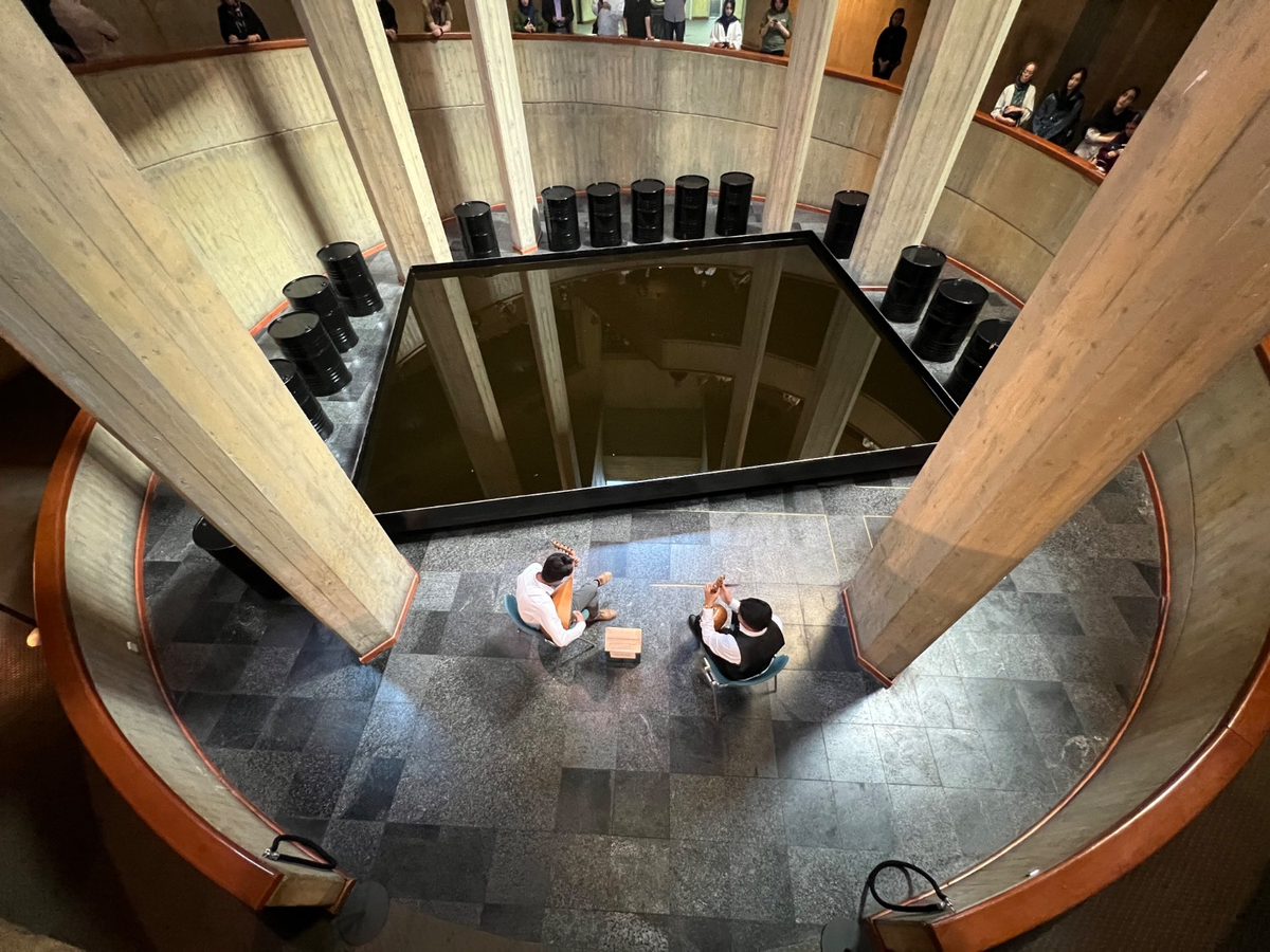 Musicians perform, as part of the Art and war programme, among oil barrels removed during the war from Noriyuki Haraguchi’s installation. Containing around 4,000 litres of oil, they have been removed to prevent spillage and fire in the event of a blast. Image: © Tehran Museum of Contemporary Art