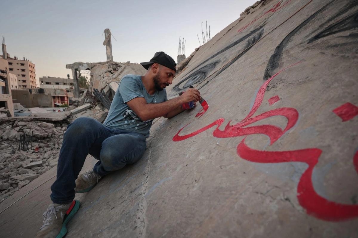 Muralist Ayman Al Hossary paints calligraphy on a destroyed building in Gaza Courtesy of the artist