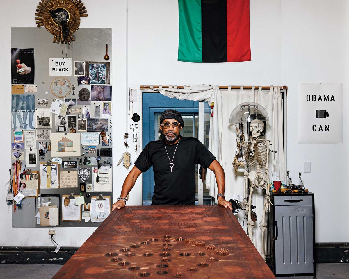 Nari Ward in his Harlem studio with a Breathing Directions (2015) panel, one of a series of works inscribed with punctured geometric patterns that reprise ancient Congolese symbols of birth, death and rebirth, which were cut as breathing holes into the floors of churches that were sheltering escaped slaves in the antebellum US Photo © Axel Dupeux