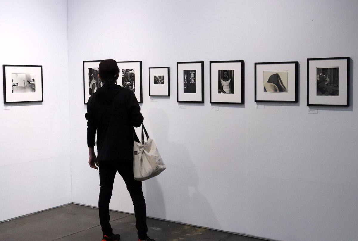 A would-be collector examines works at a photography fair Photo by Elvert Barnes, via Flickr