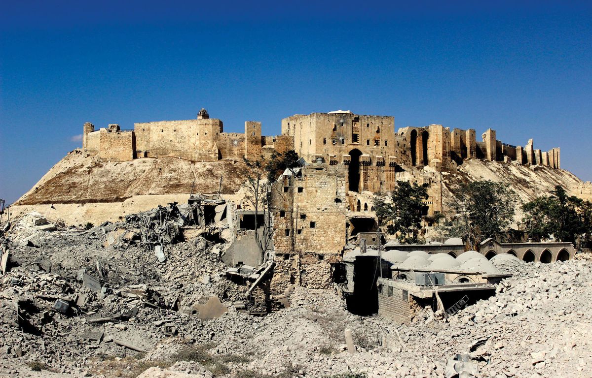 The entrace to the Citadel of Aleppo, with the ruins of the Khusruwiyah Mosque and the Carlton Hotel © Sultan Kitaz, 2014