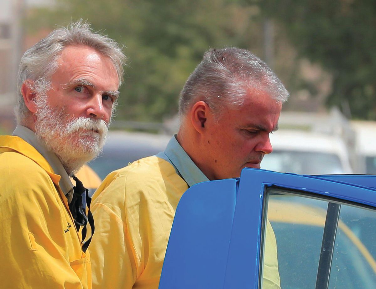 Jim Fitton (left) in handcuffs outside a court in Baghdad in May REUTERS/Thaier