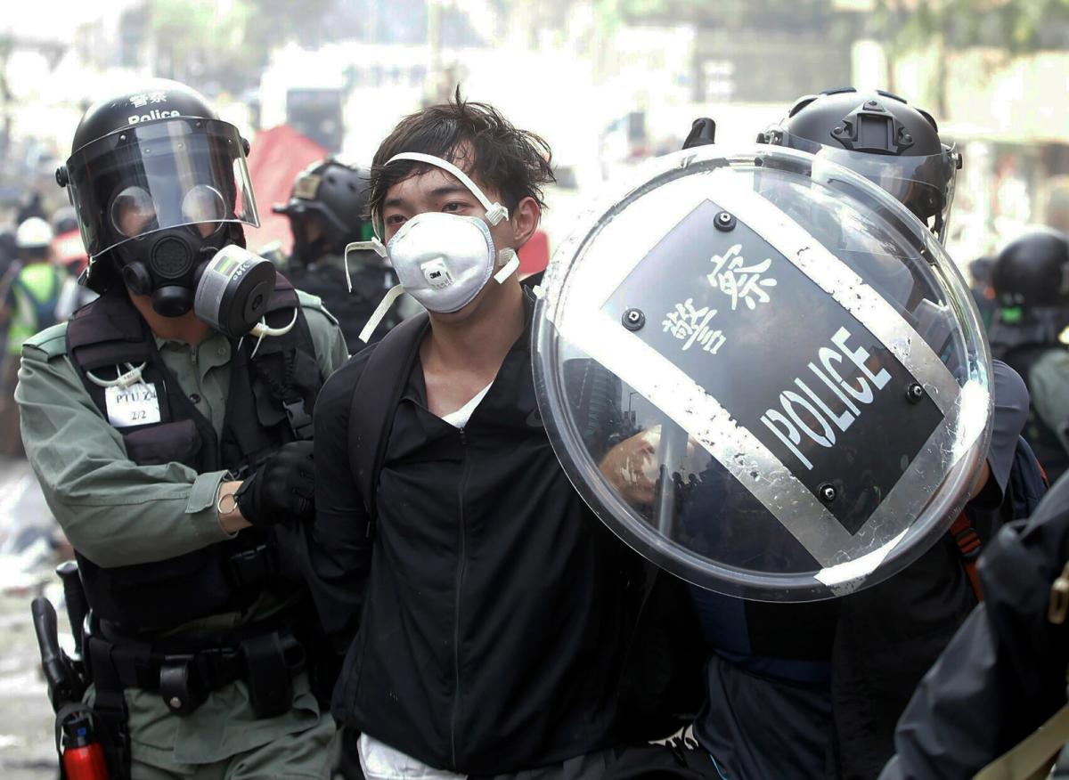 Police officers detain a protester near the Hong Kong Polytechnic University in Hong Kong on 18 November 2019; Hong Kong police have swooped in with tear gas and batons as protesters who have taken over a university campus make an apparent last-ditch effort to escape arrest AP Photo/Achmad Ibrahim