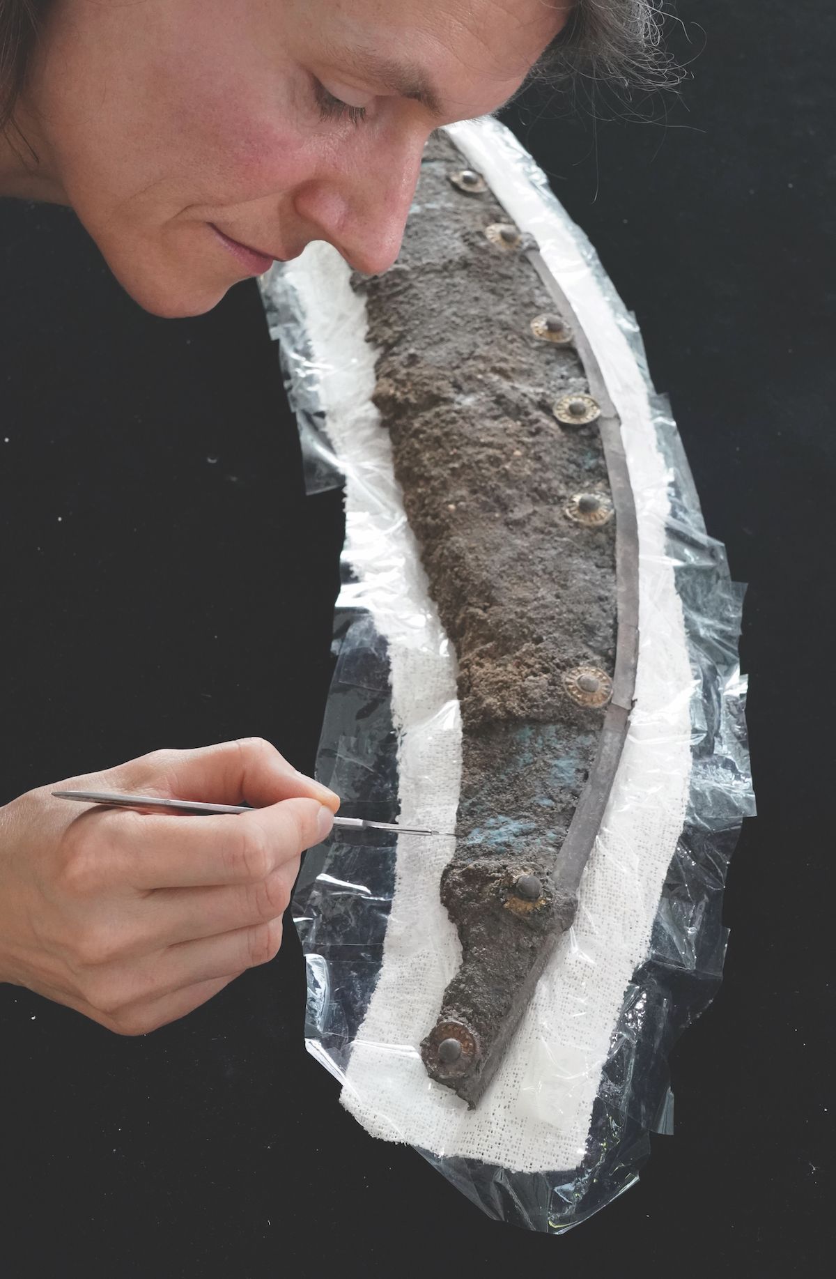 A conservator works on the 1,700-year-old wooden shield, unearthed in a Roman tomb in central Germany Peter Endig/dpa-Zentralbild/dpa/Alamy