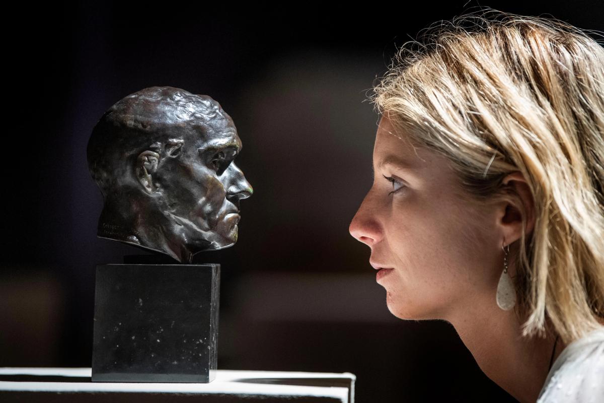 A member of Bonhams staff looks at a sculpture by Auguste Rodin before it is offered for sale. PA Images / Alamy Stock Photo