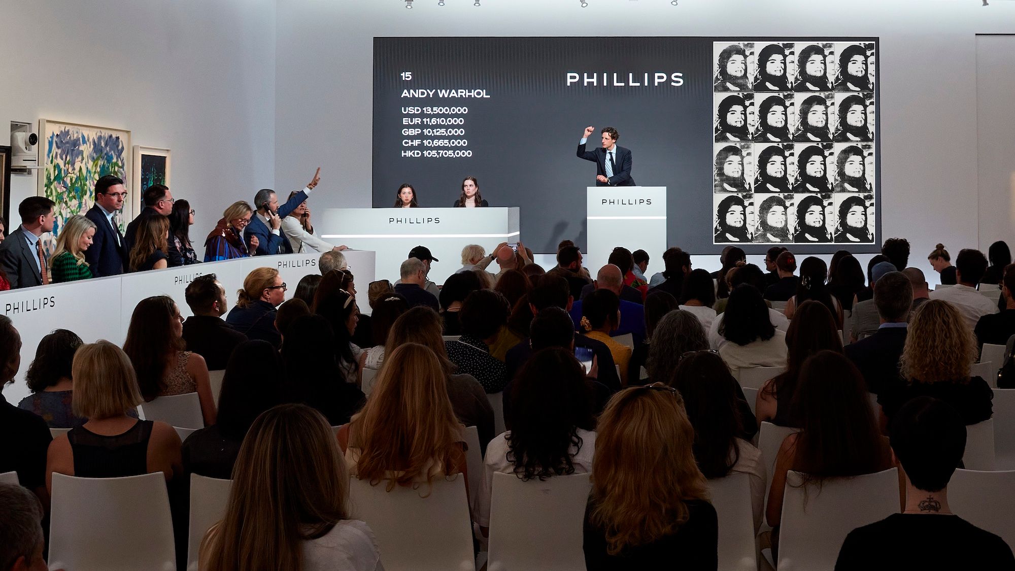 Phillips auctioneer Henry Highley fields bids for Andy Warhol's Sixteen Jackies, the top lot at the auction house's 19 May evening sale in New York Courtesy Phillips