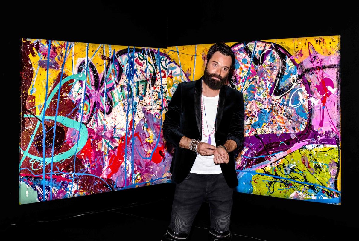 Sacha Jafri in front of part of the painting Courtesy of Humanity Inspired