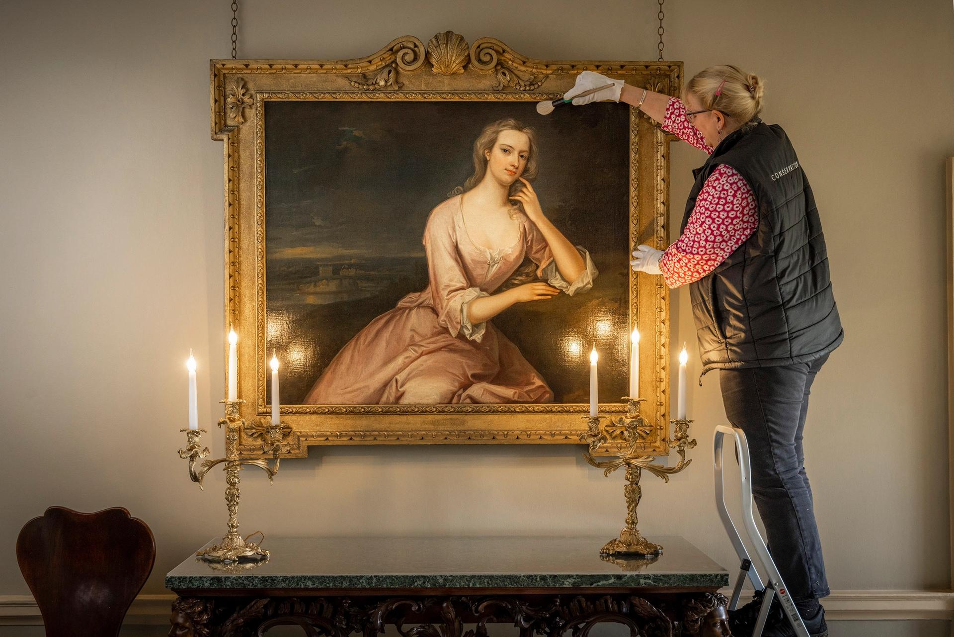 Finishing touches: Kate Perks, Marble Hill's collections conservator cleaning a portrait of Henrietta Howard, Countess of Suffolk, in the building's Tetra hall Photo: Christopher Ison © English Heritage 
