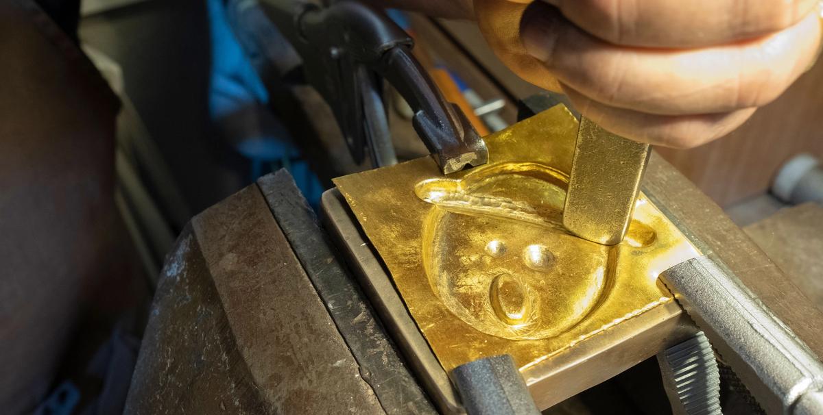 Nicolas Hugo hammers out a mould for a medallion 