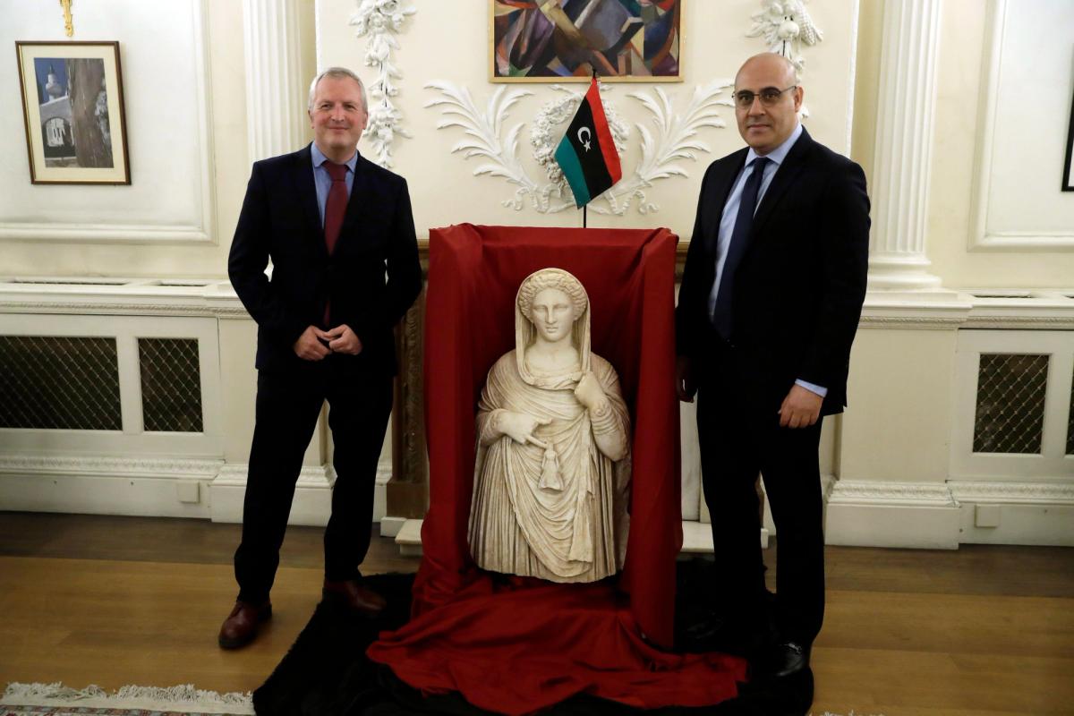 British Museum's Peter John Higgs, left, with Mohamed Elkoni, the Charge d'Affaires of the Libyan embassy, next to a 2nd century BC funerary statue from the ancient Greek city of Cyrene.

Photo: Associated Press / Alamy Stock Photo