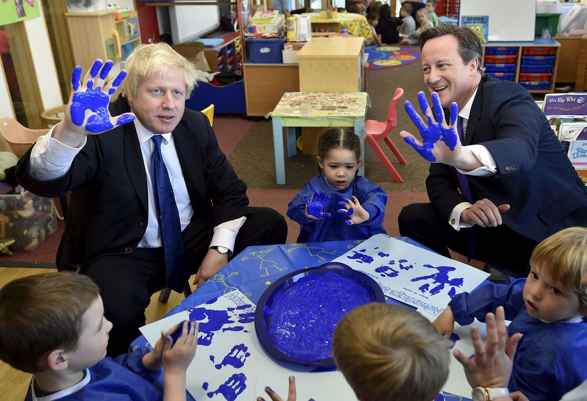 Boris Johnson in 2015 when he was Mayor of London with the UK’s then prime minister David Cameron taking part in a hand-printing session with children Photo by Toby Melville - WPA Pool / Getty Images