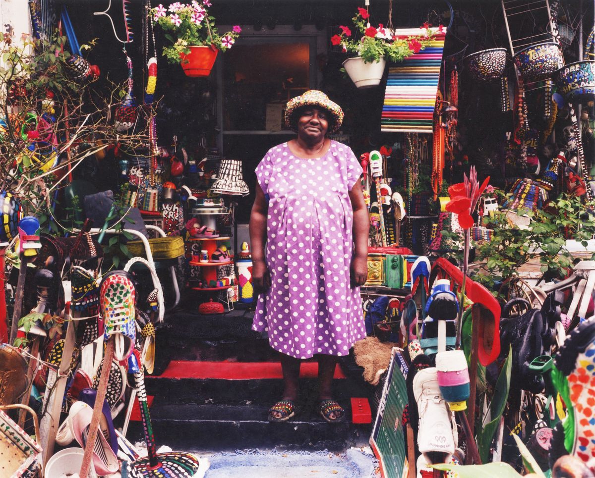 L.V. Hull Home & Studio, Kosciusko, Mississippi. Artist L.V. Hull stands within her art environment on the front steps to her home. Photo by Bruce West