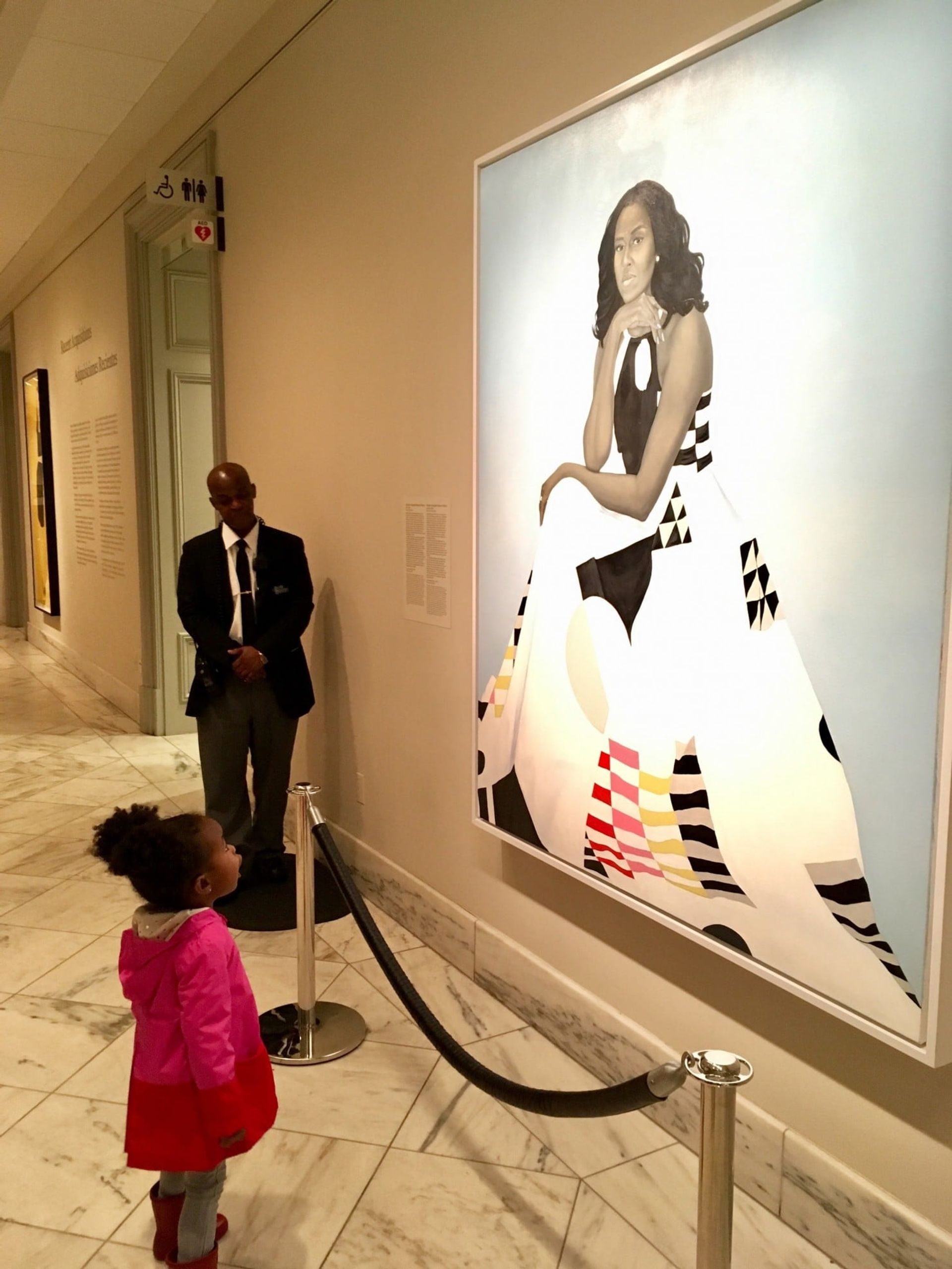 Parker Curry, 2, in front of a portrait of Michelle Obama Photo: Ben Hines