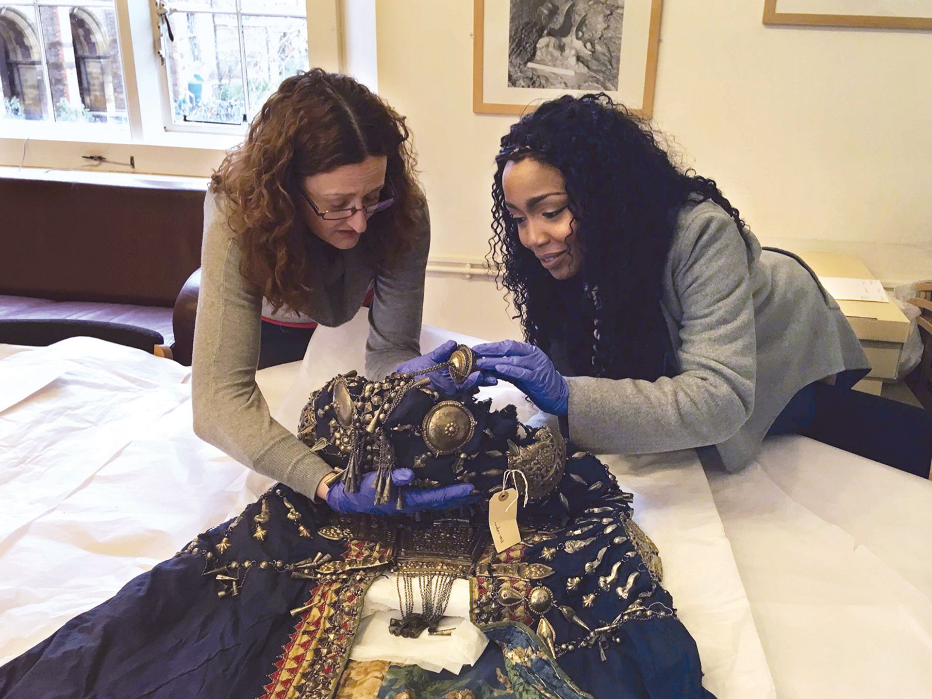 时尚设计师和活动家Vicky Ngari(右)和收藏经理Rachel Hand在剑桥考古和人类学博物馆的收藏中检查一件19世纪的埃塞俄比亚皇家长袍